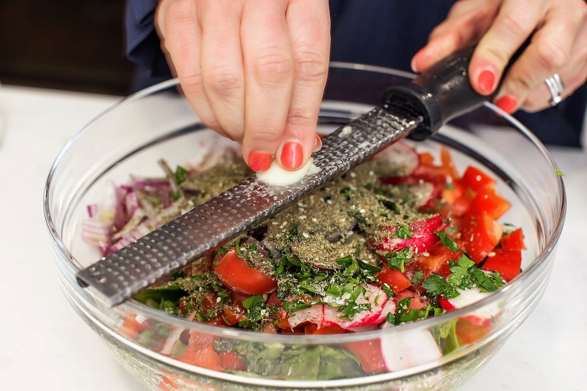 Liz grating garlic over syrian salad