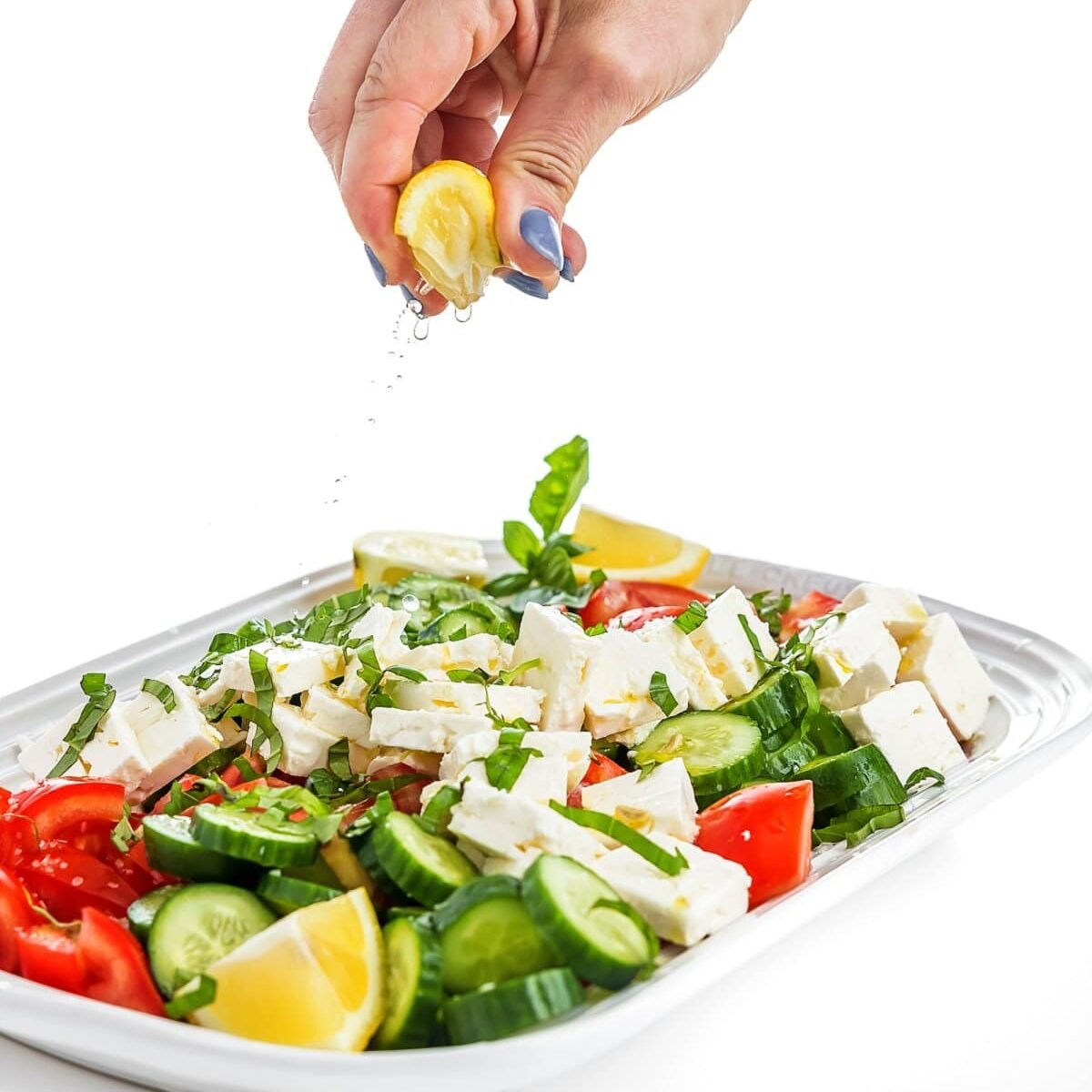 view of tomato salad with lemon being squeezed onto it