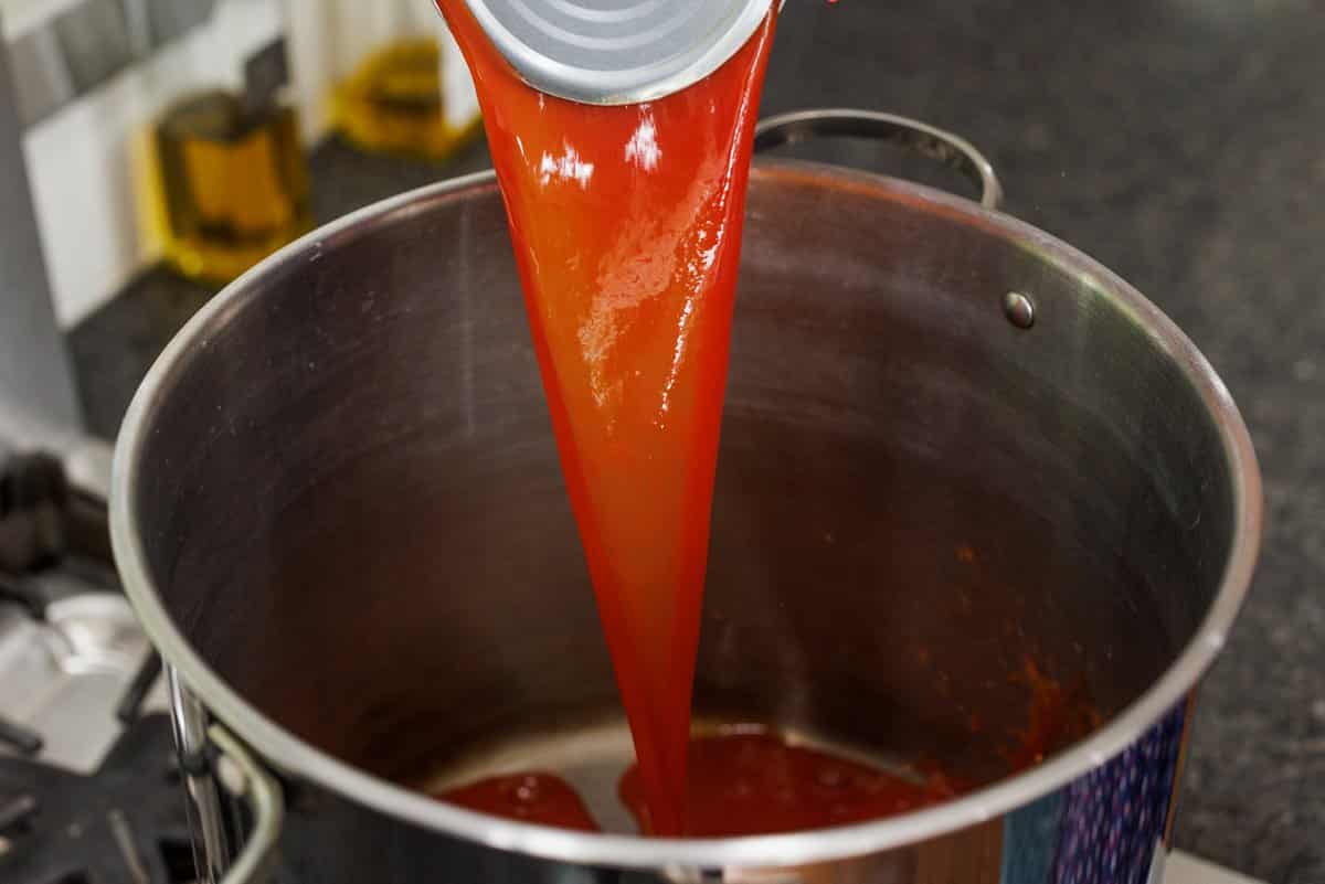 Adding tomato juice to large pot