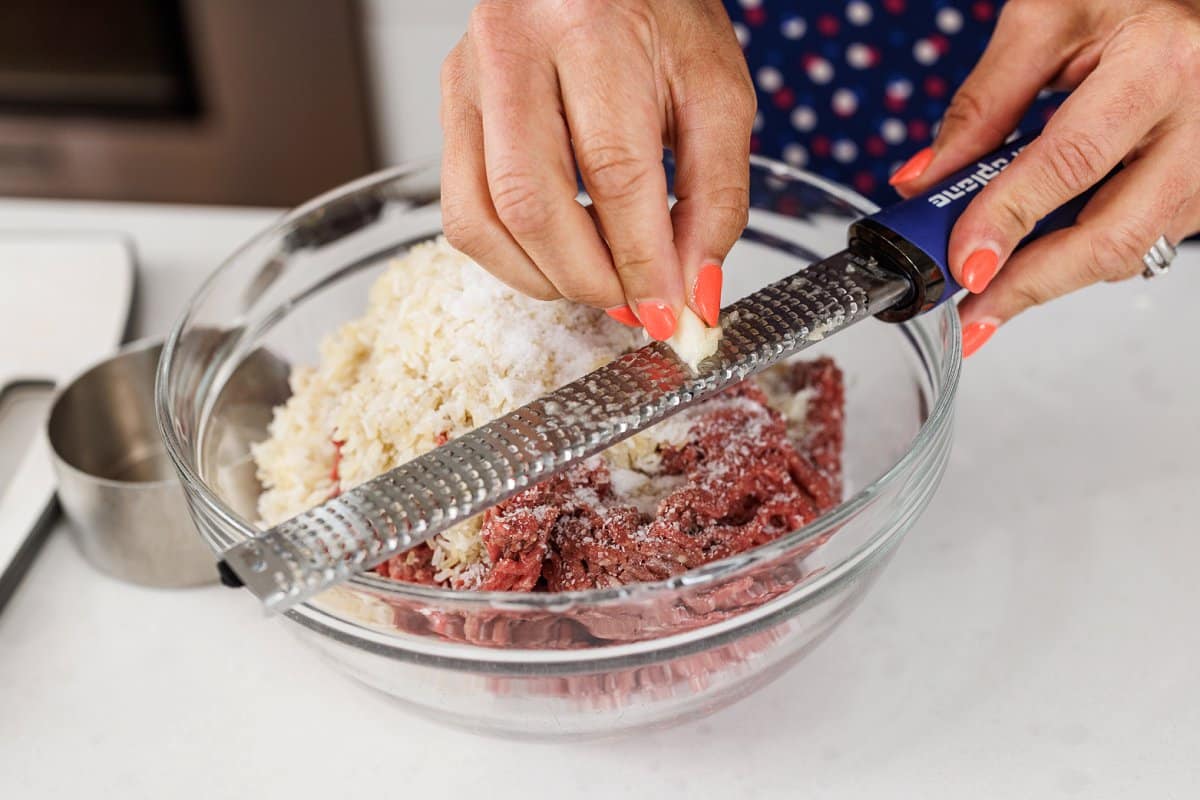 Freshly grating garlic into bowl