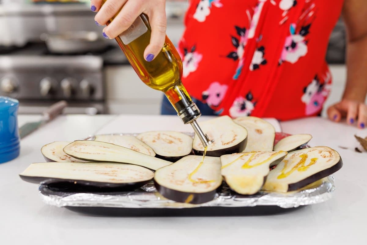 Drizzling eggplant with olive oil