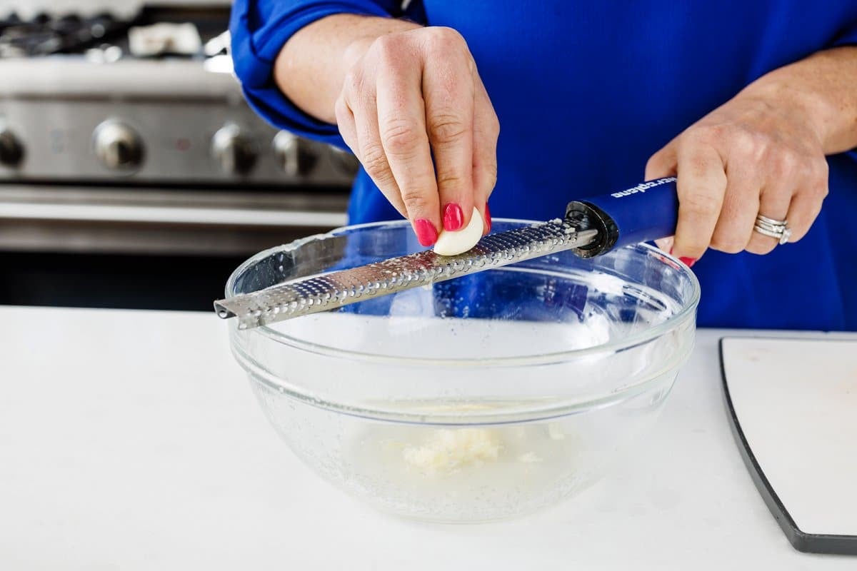 Grating garlic into bowl 1