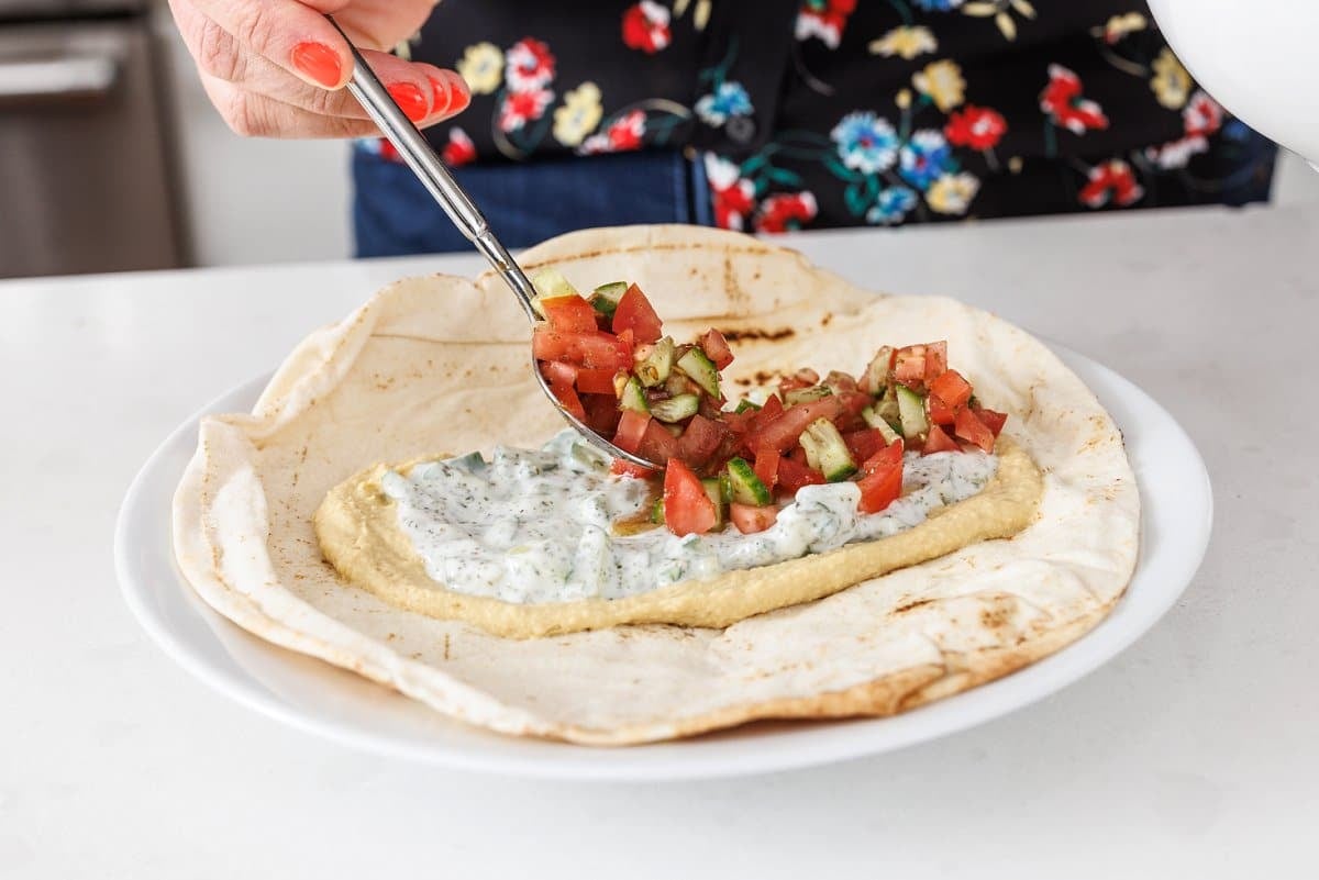 Spreading vegetable salad in pita