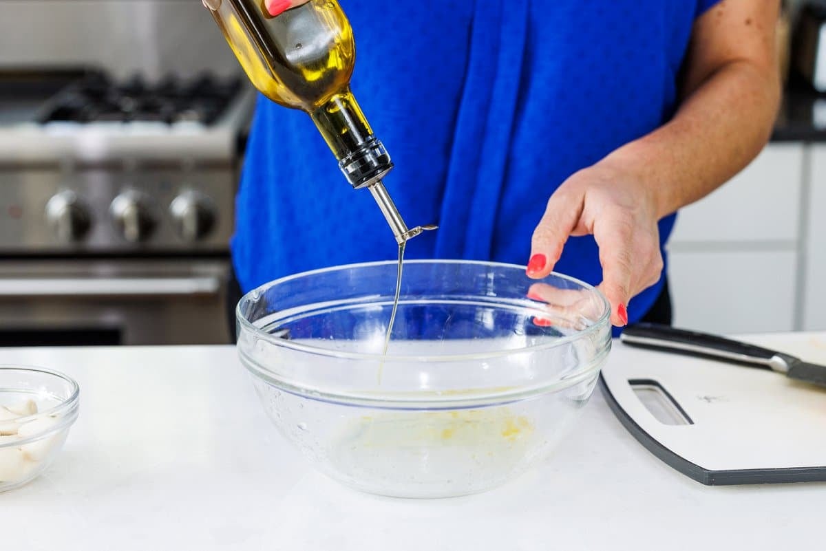 Adding olive oil to bowl