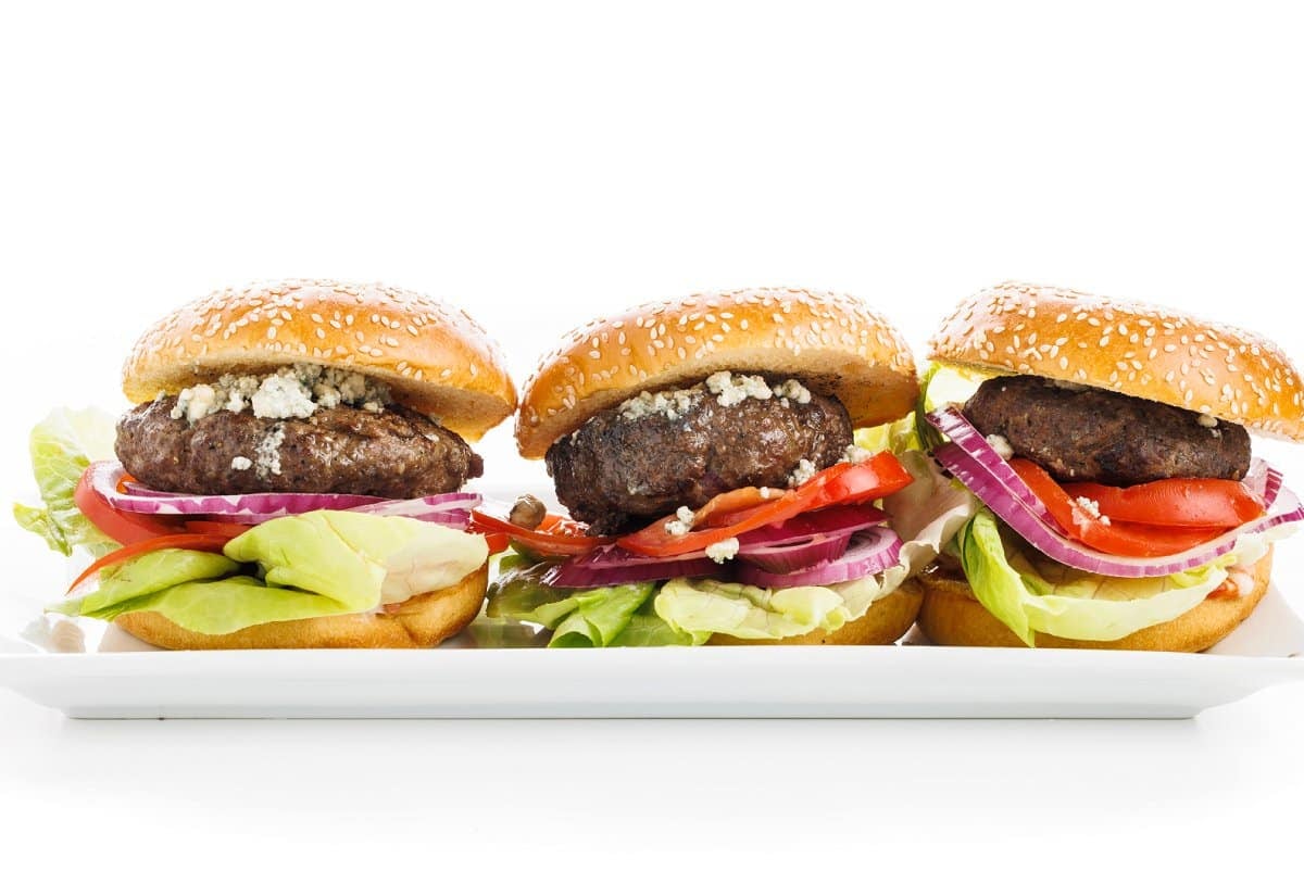 Stuffed blue cheese burgers in a row.