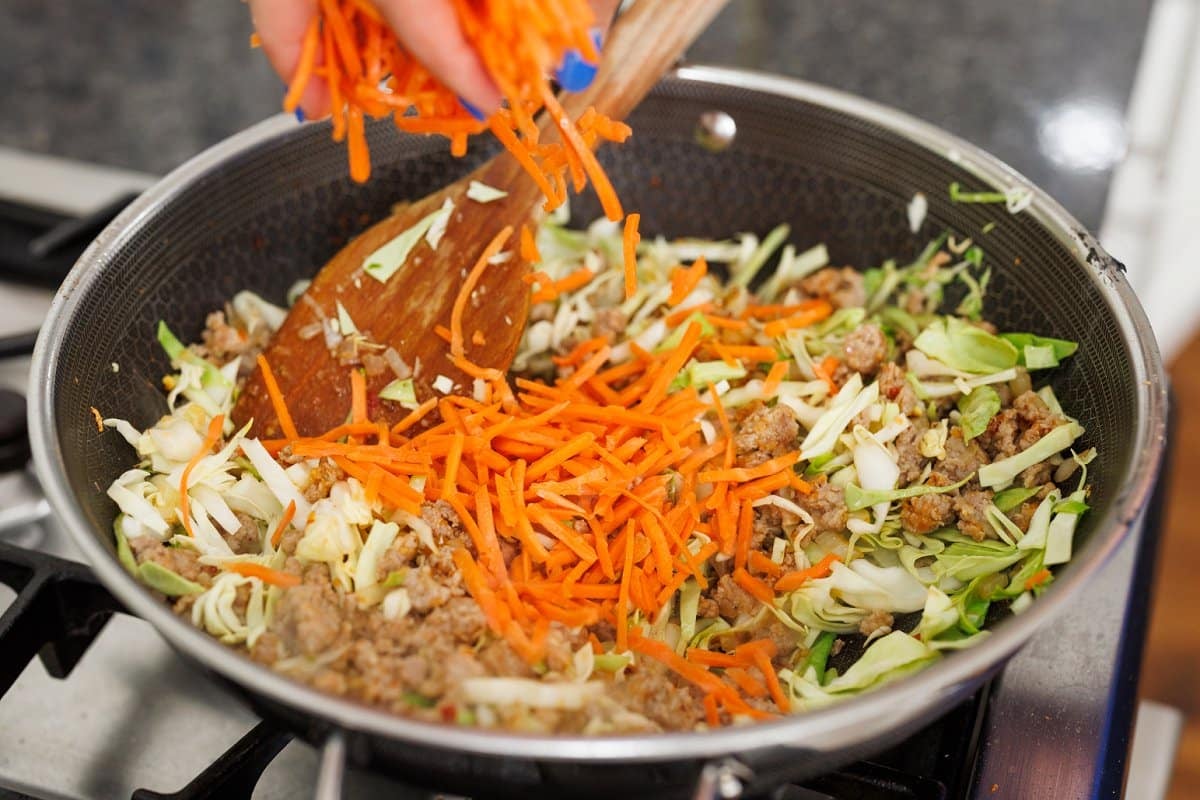 Adding carrots to wok