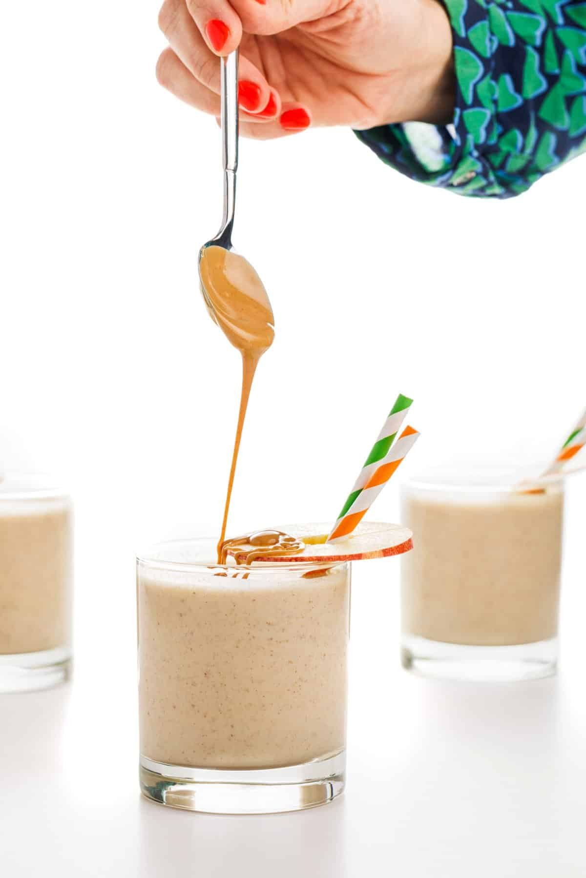 Drizzling peanut butter on apple peanut butter smoothie.