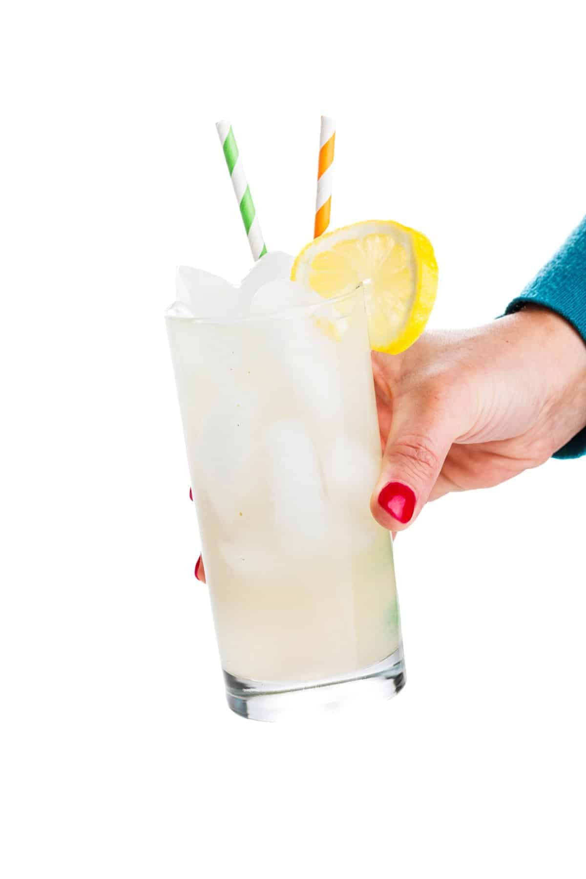 Holding a glass of orange blossom lemonade.