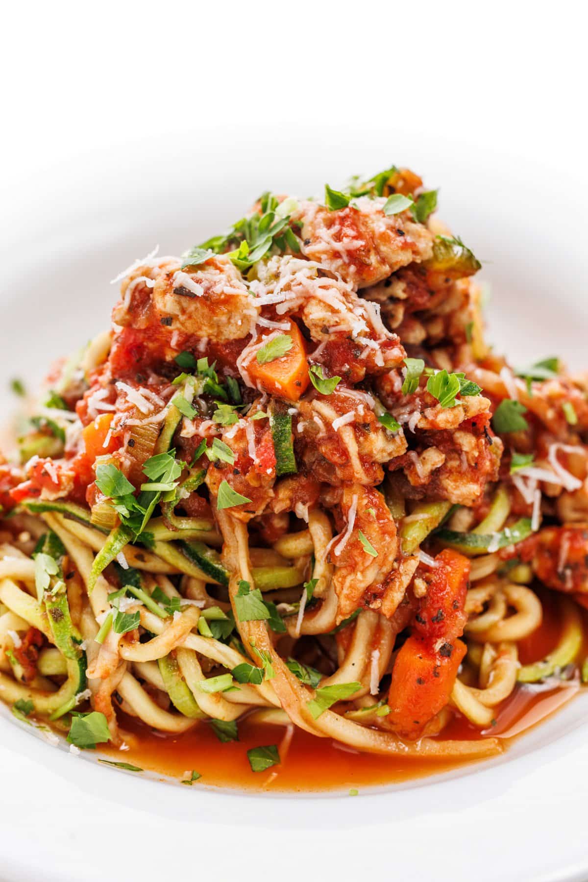 Turkey bolognese zucchini pasta piled high in a shallow white bowl.
