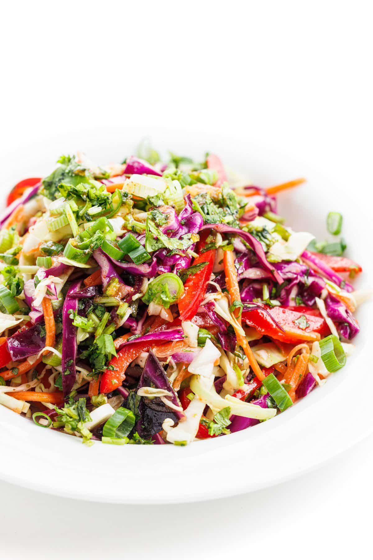 Mexican slaw with honey lime vinaigrette in a white bowl.
