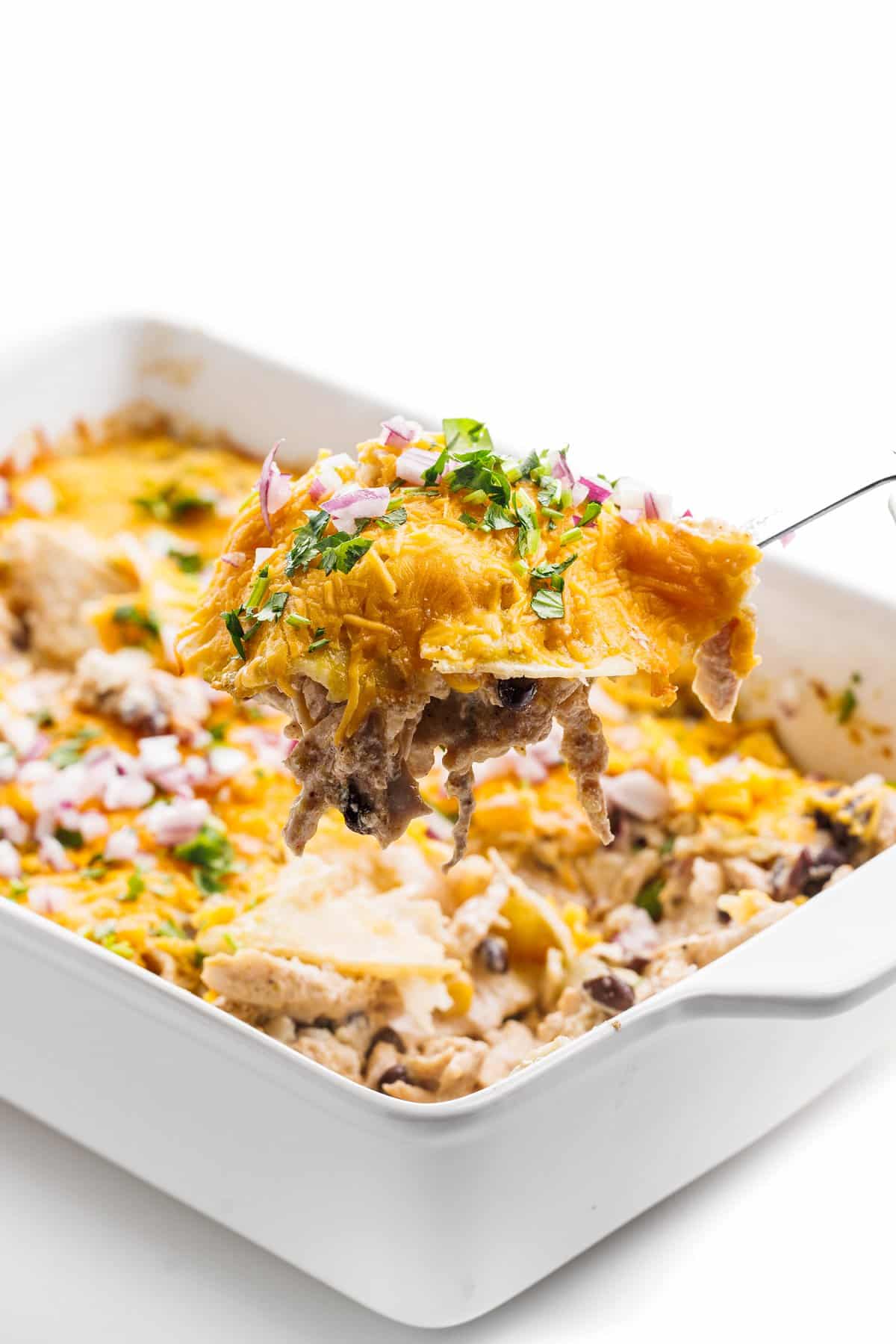 Serving Mexican lasagna with chicken and beans.
