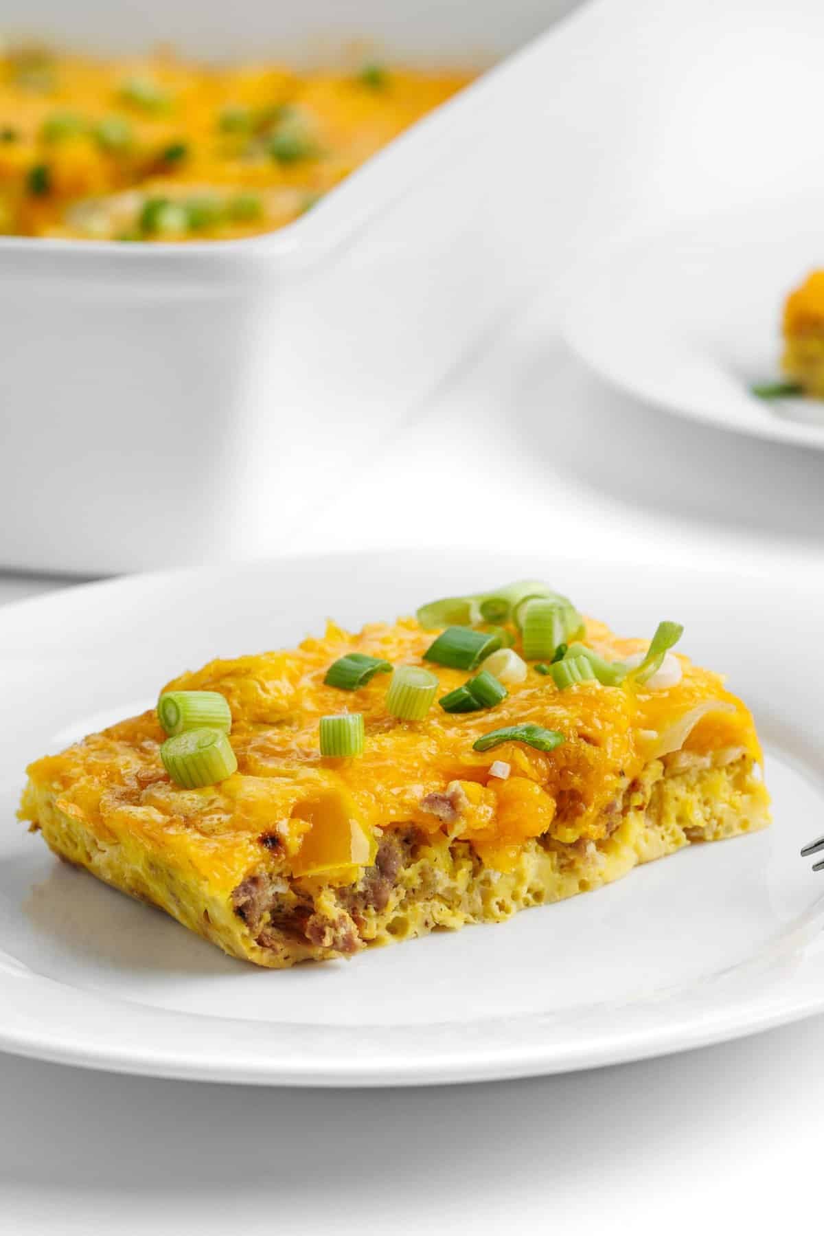 A slice of cheesy sausage and pepper egg bake on a plate.