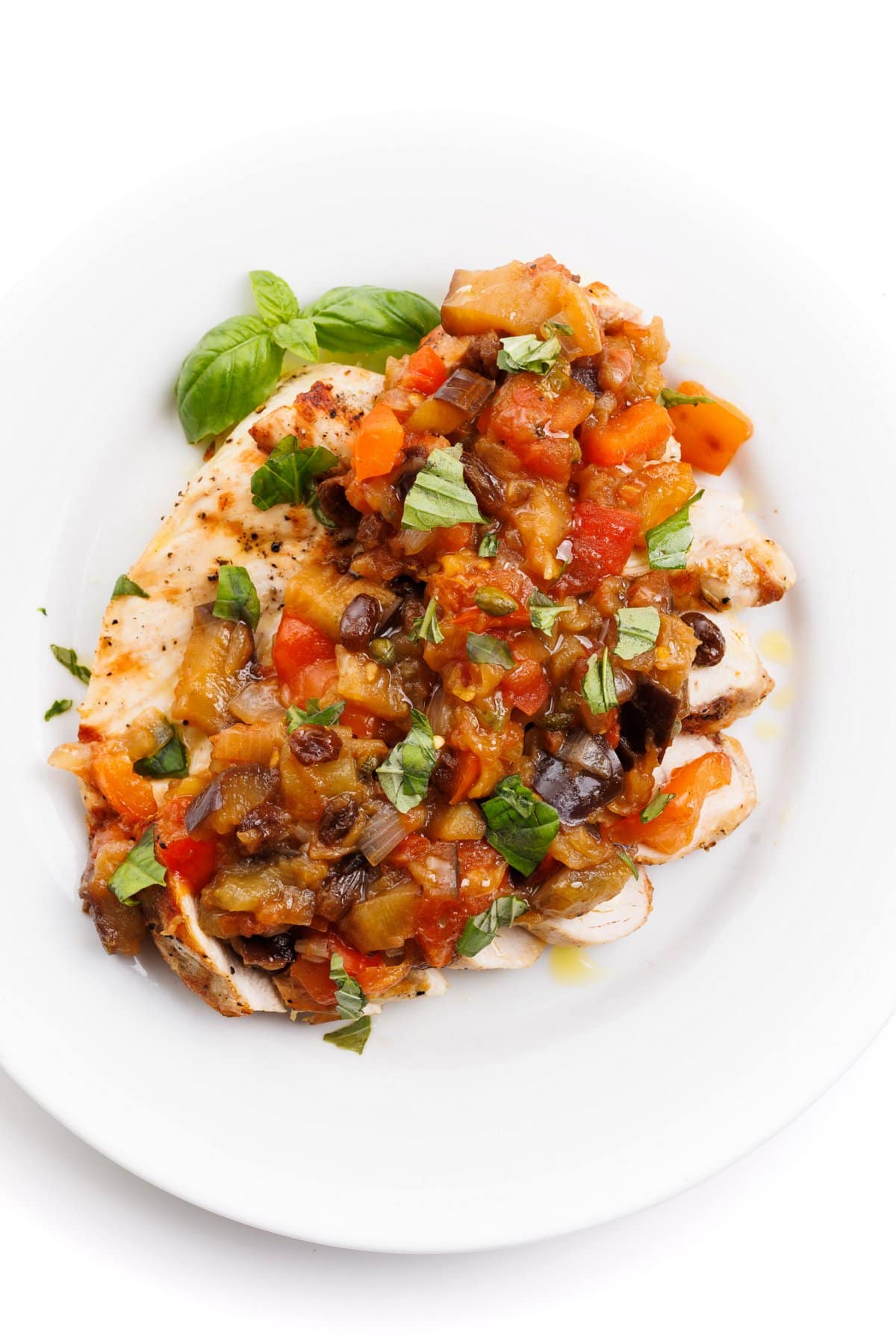Grilled chicken with eggplant caponata over the top and fresh basil.