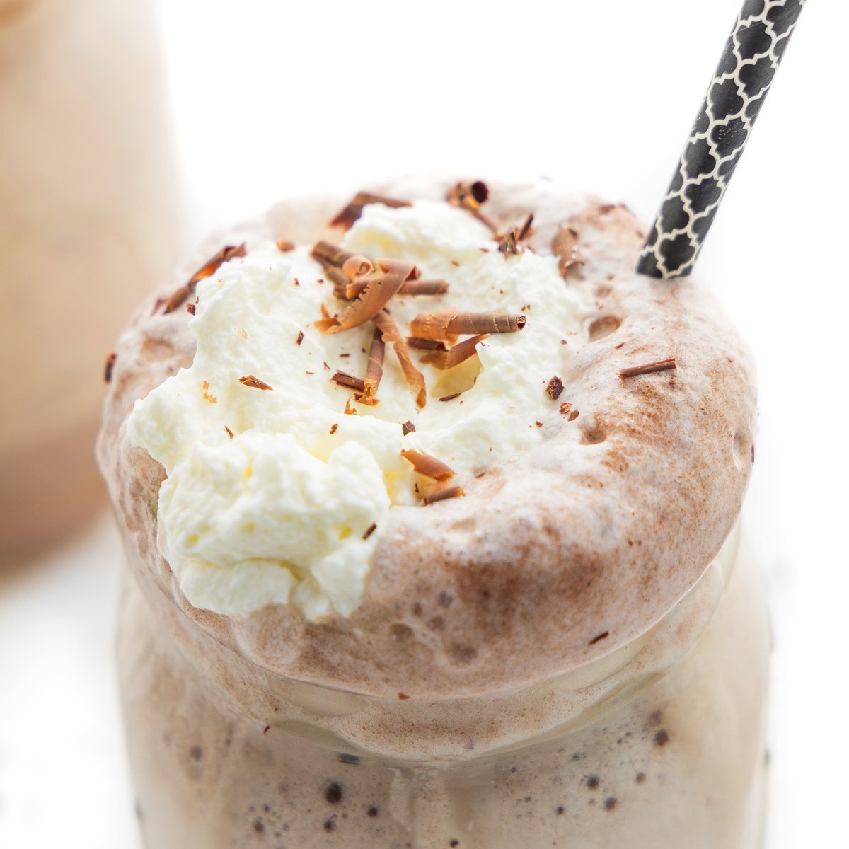 Top of a mug of frozen hot chocolate topped with whipped cream and chocolate shavings.