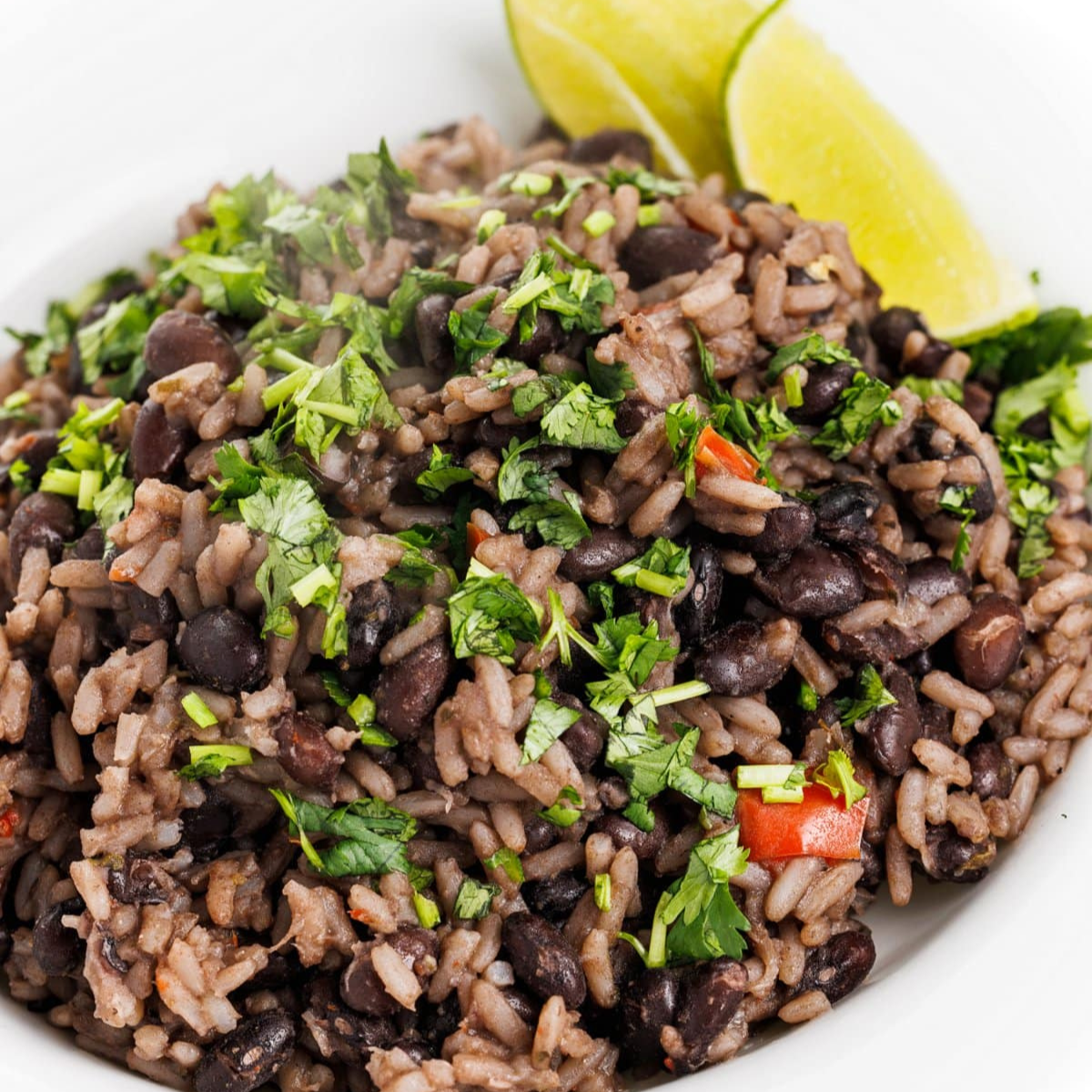 Cuban black beans and rice garnished with fresh cilantro in a bowl.