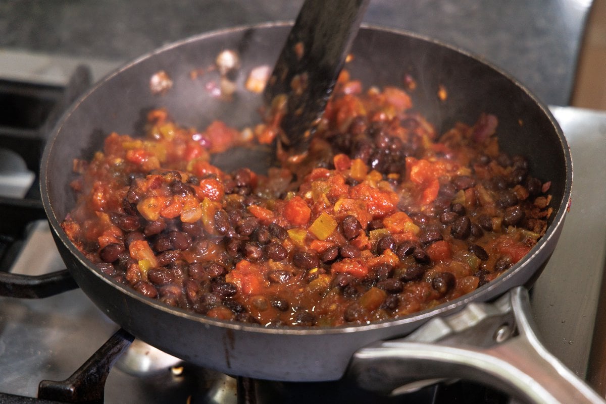 Black beans added to pan with salsa.