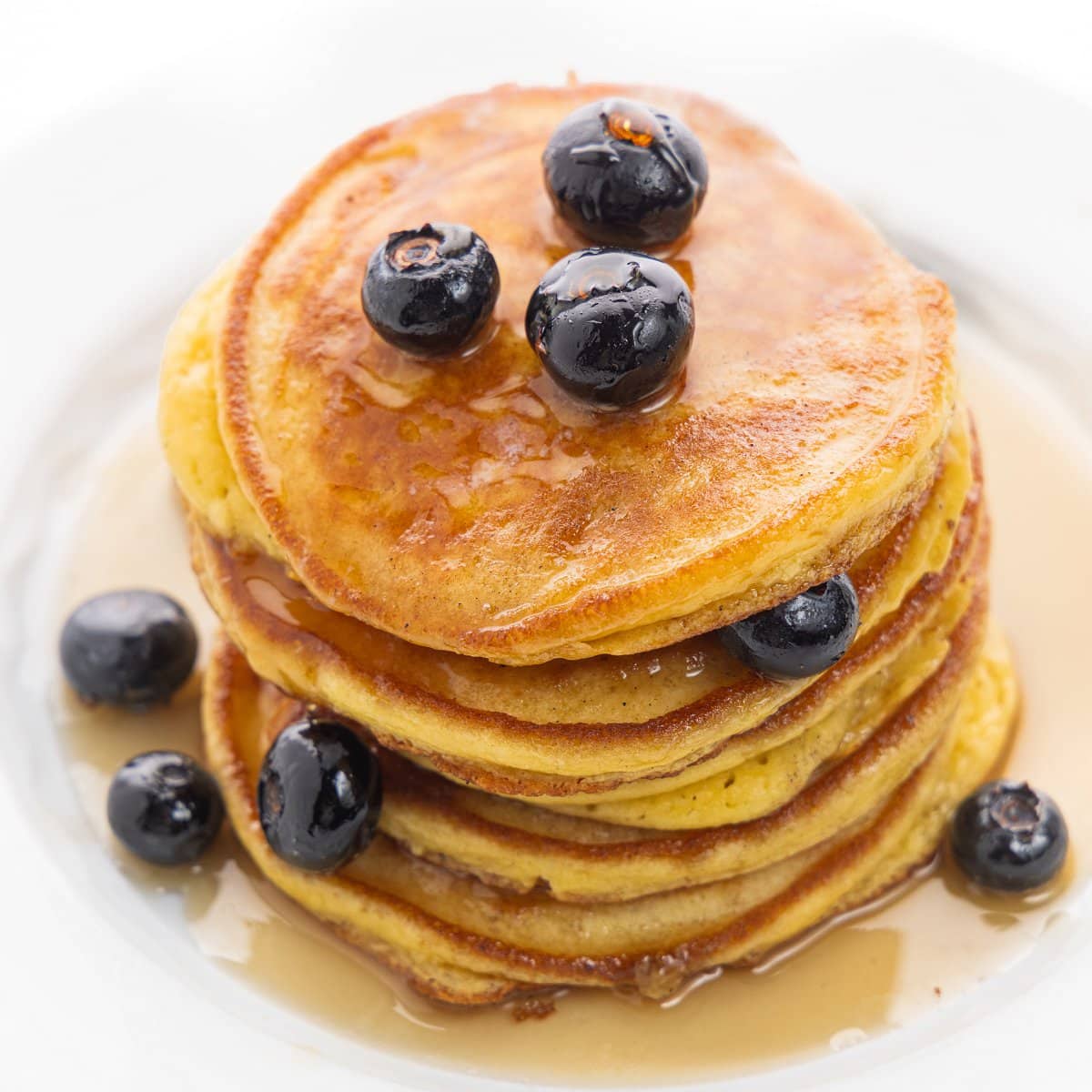 Protein packed pancakes with syrup and blueberries.