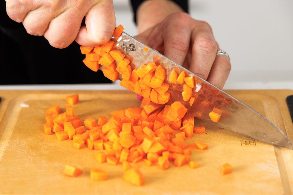 Dicing carrots with a sharp knife.