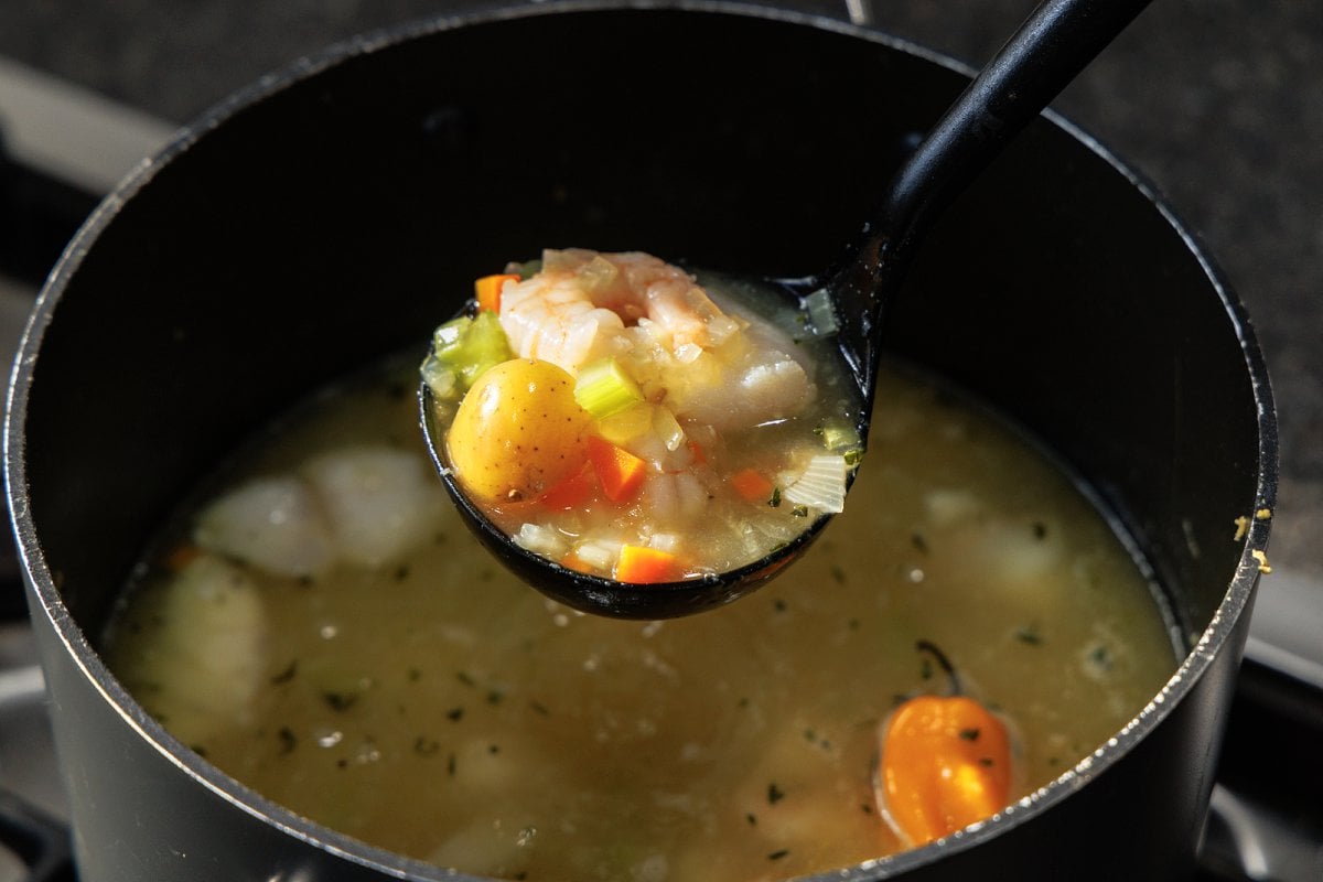 Ladle full of Caribbean fish soup, or fish tea.