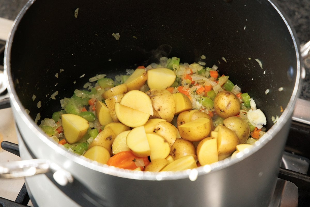 Cut potatoes added to mirepoix in soup pot.