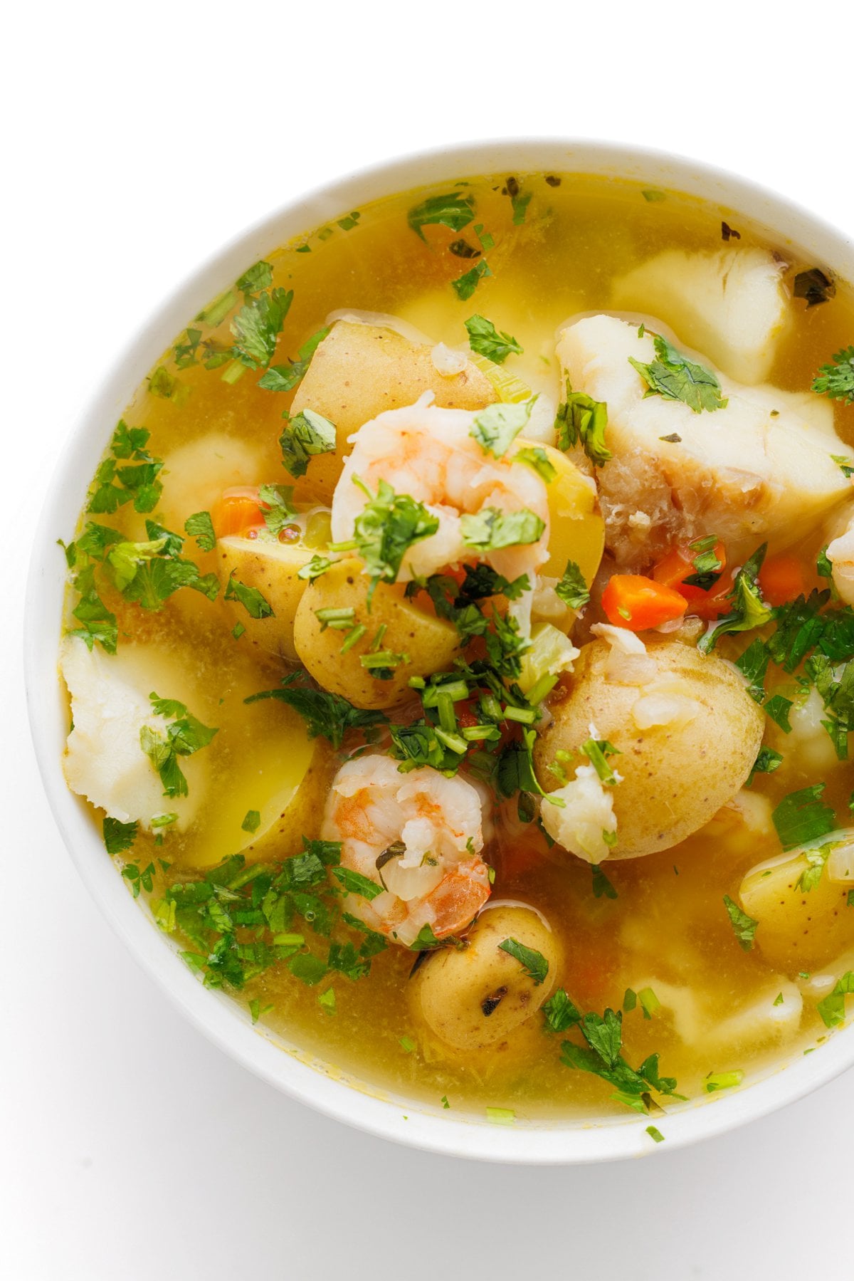 Top down view of Caribbean fish soup in a bowl, garnished with fresh cilantro.