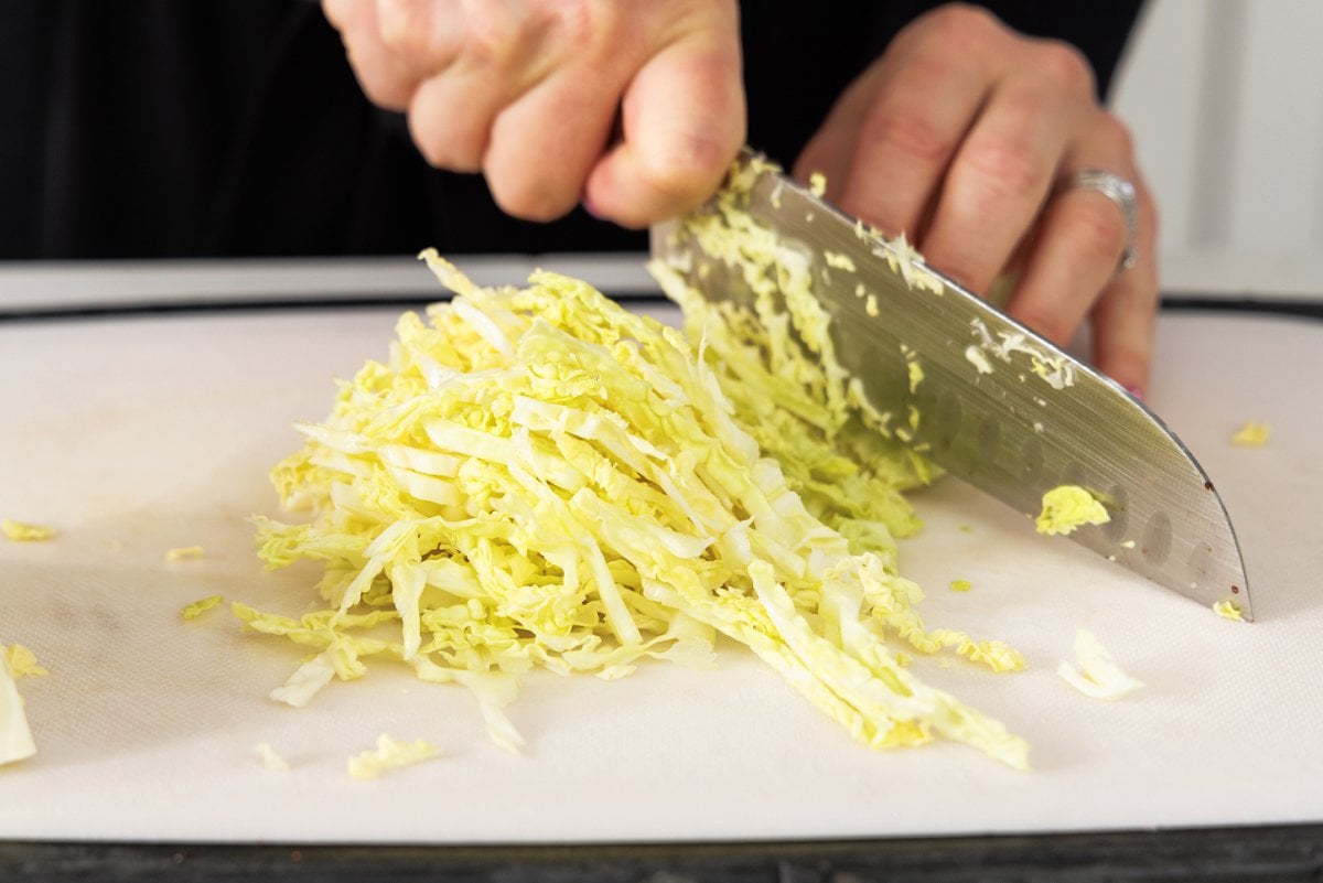 Shedding cabbage with a sharp knife.