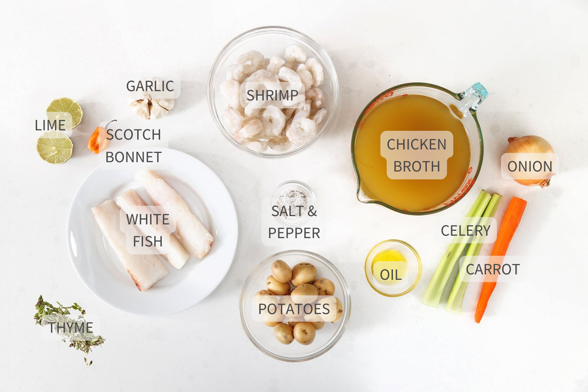 Labeled ingredients for Caribbean fish soup on a white counter.