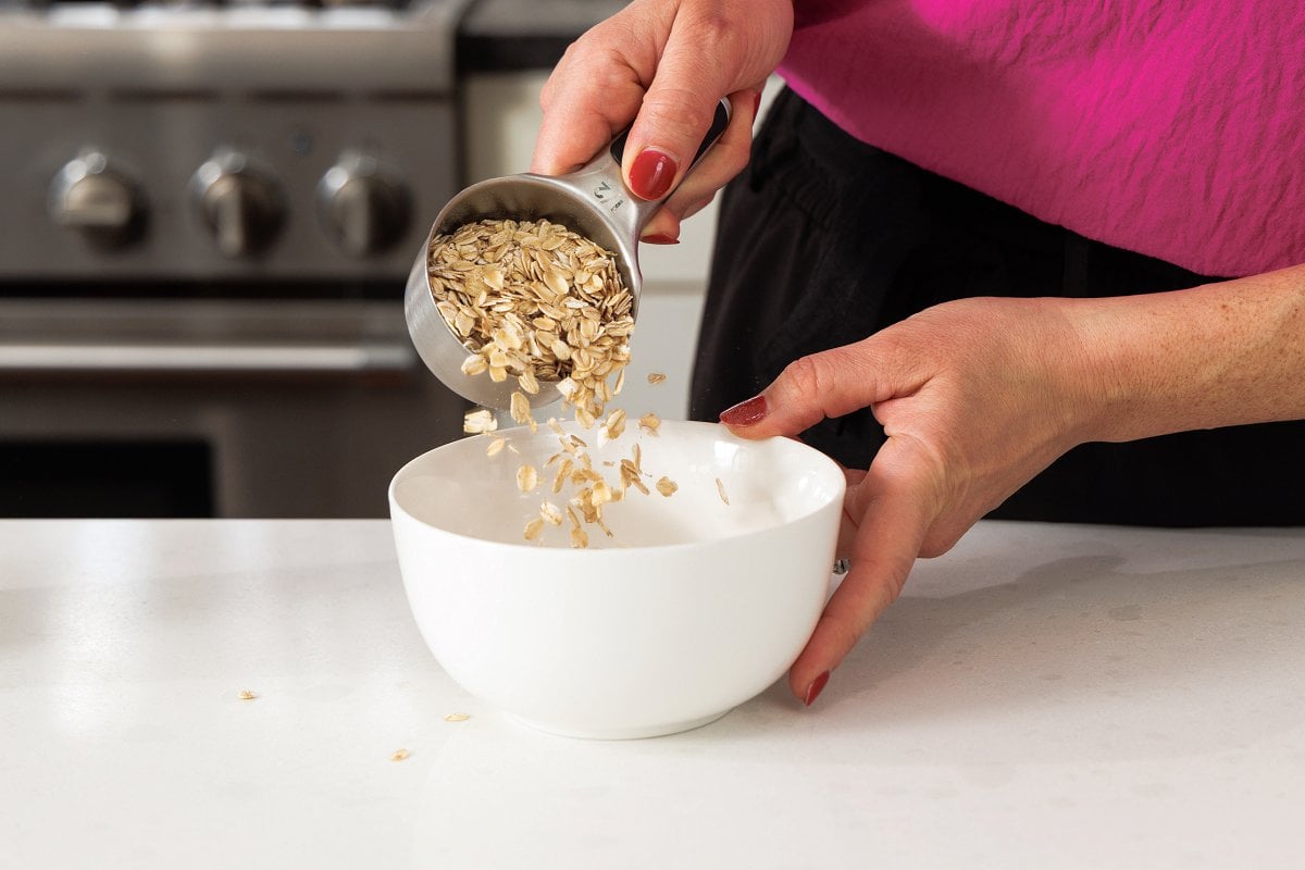 Adding oats to microwave safe bowl.
