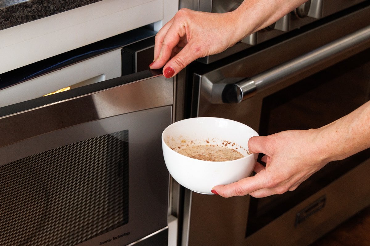 Putting bowl of oatmeal in microwave.