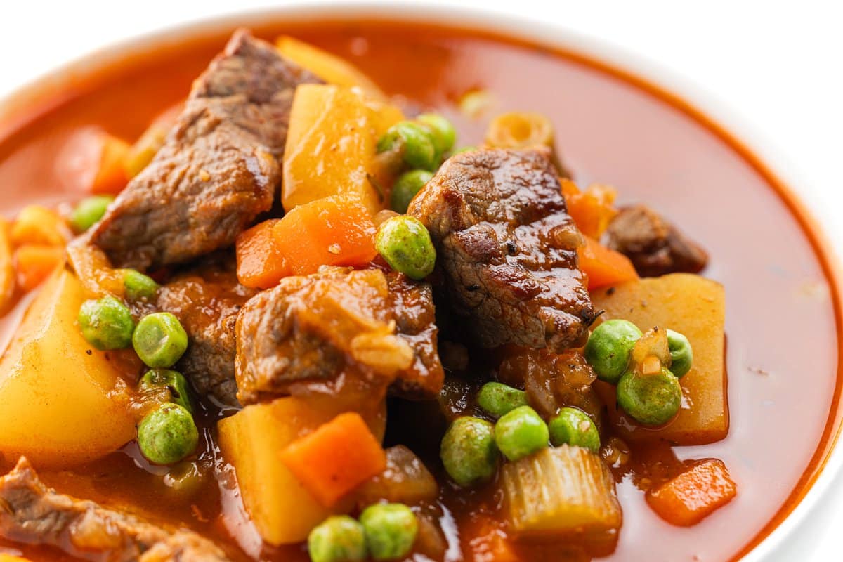 Vegetable beef soup with carrots and peas.