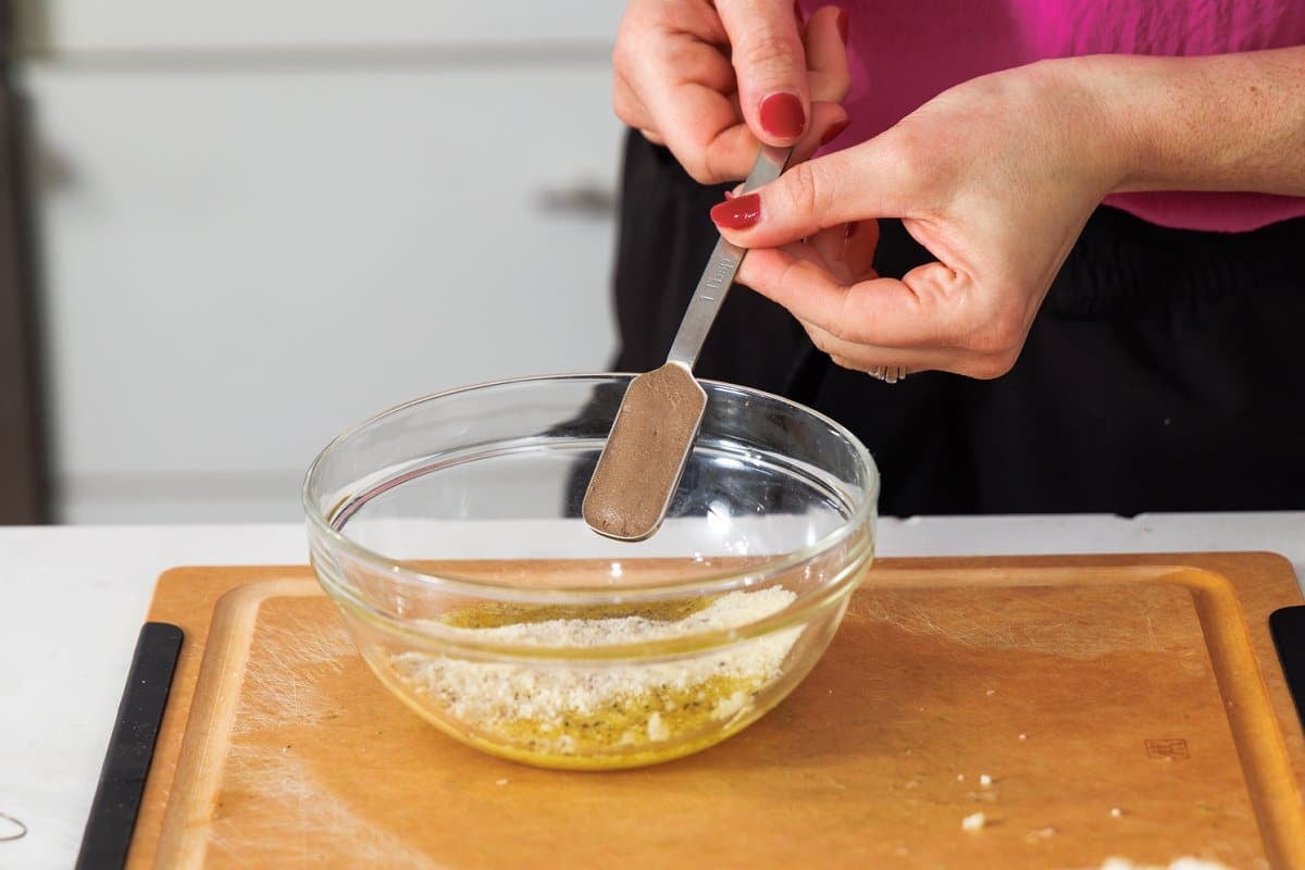 Adding anchovy paste to bowl.