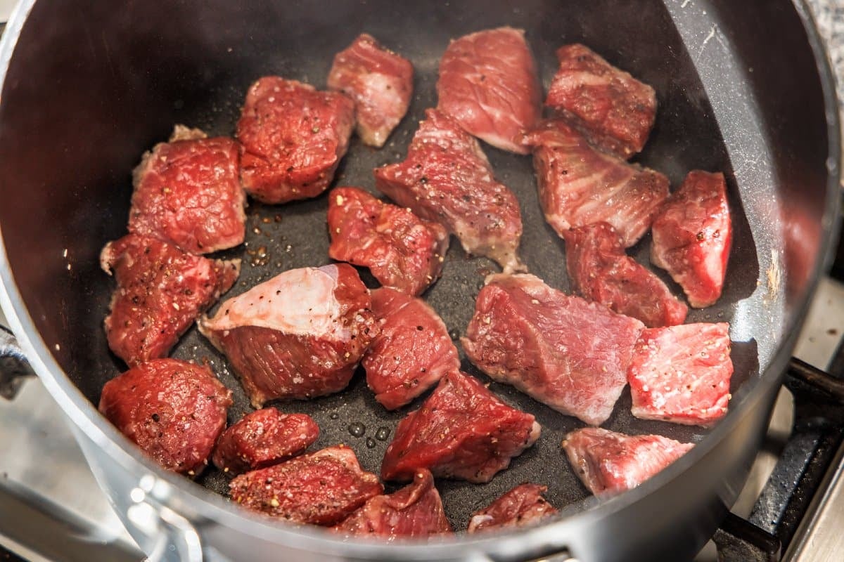 Cooking sirloin beef in the bottom of a pot.