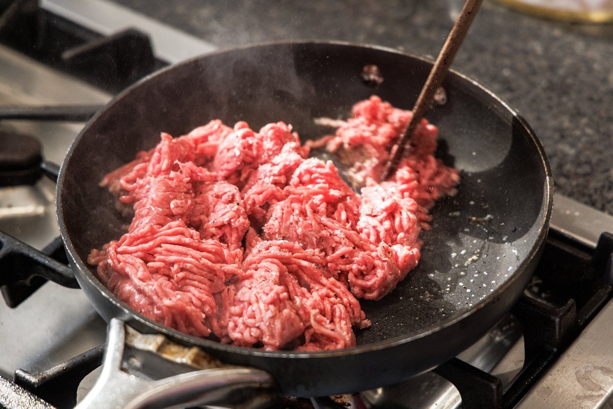Cooking ground lamb in pan.