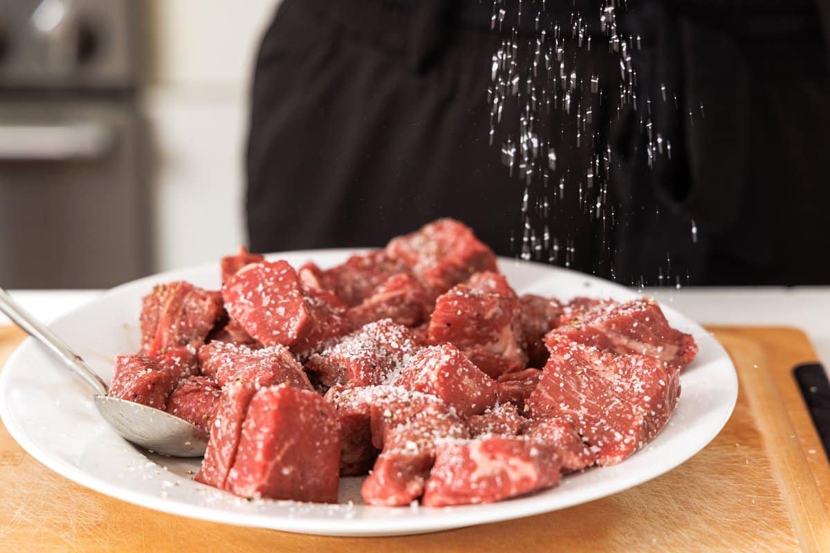 Seasoning beef with salt.