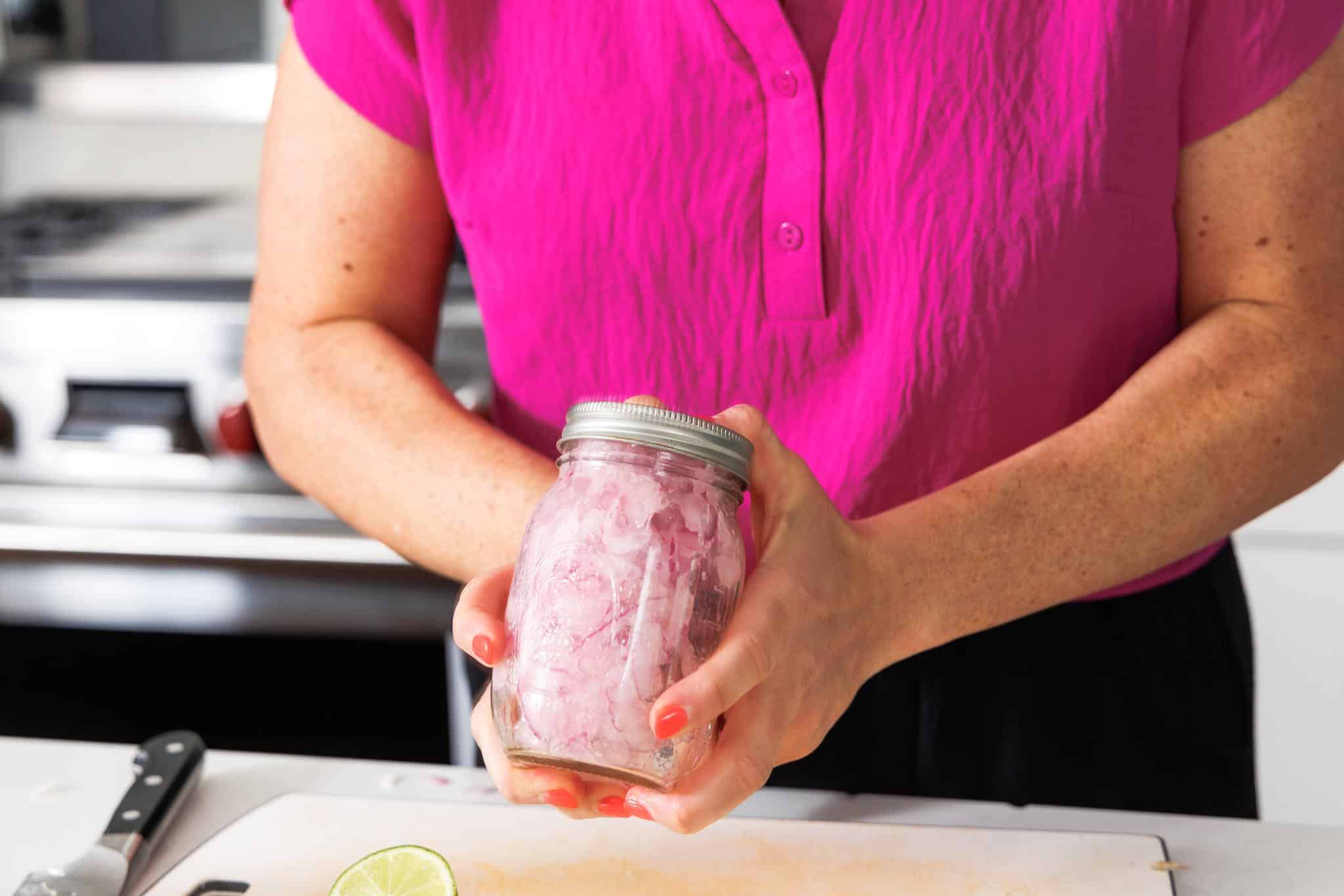 Shaking up red onions in a jar.