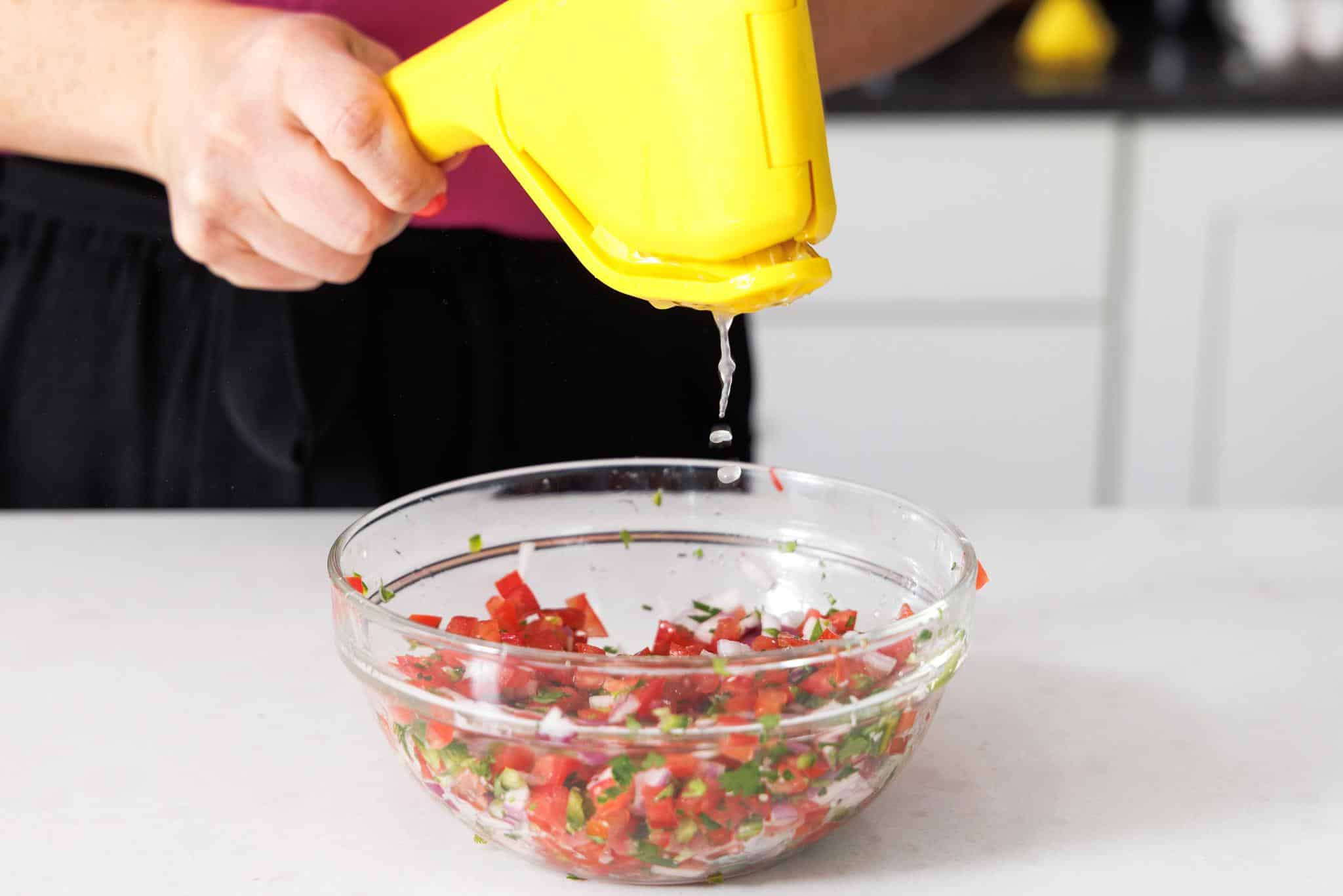 Juicing a lime into pico de gallo.