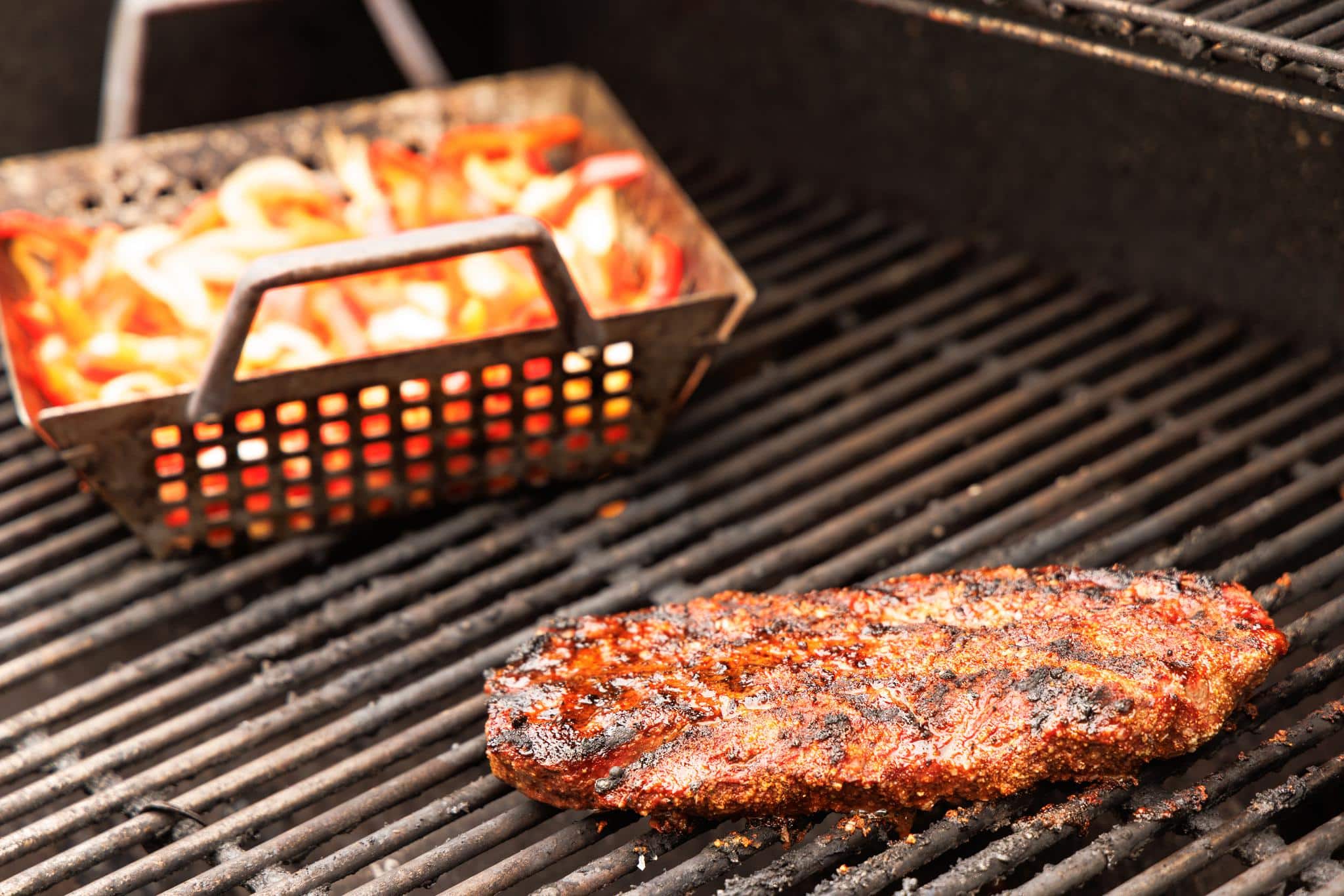 Flank steak and veggies cooking on the grill.