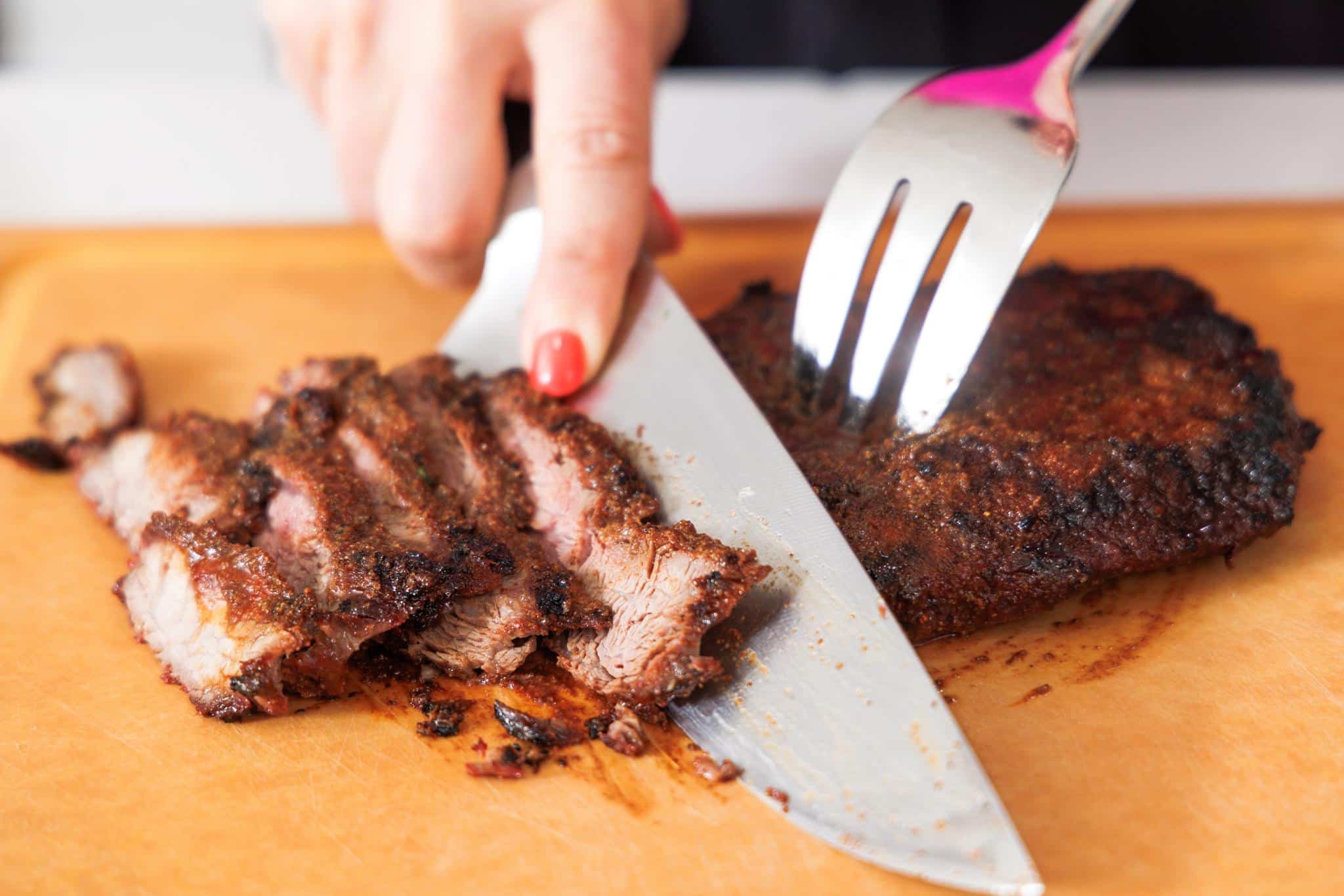 Slicing cooked flank steak.