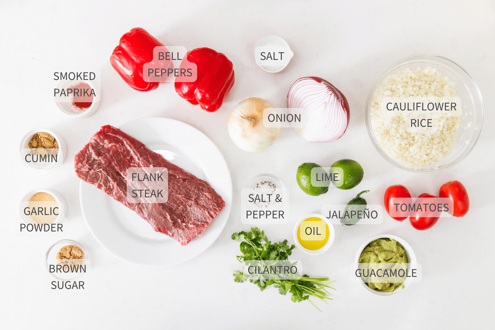 Labeled ingredients for steak fajita bowls on a white counter.