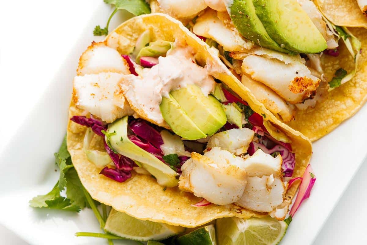 A couple grilled baja fish tacos on a platter.