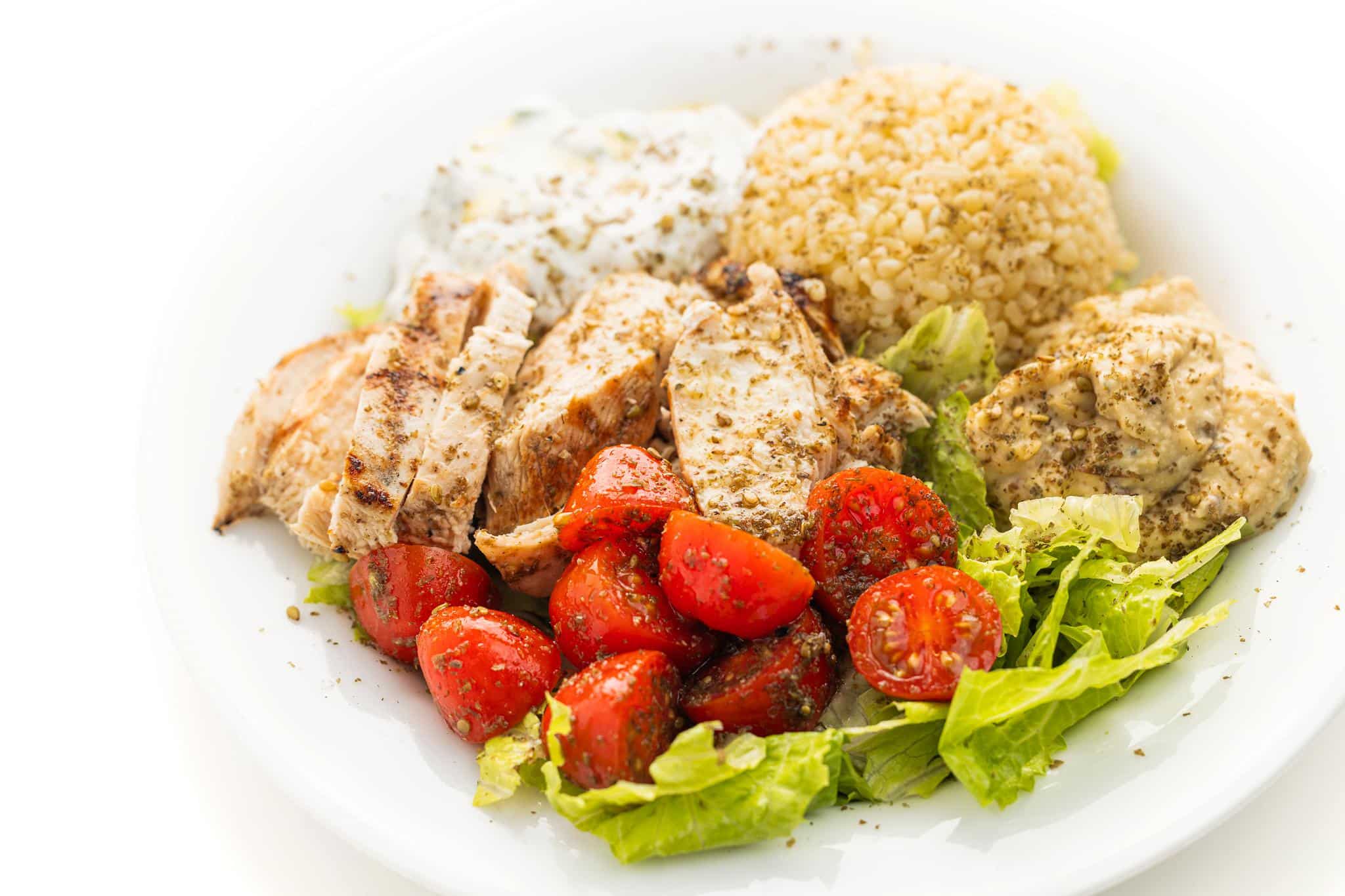 Chicken tawook bowl with tomato salad, quinoa, lettuce, and laban.
