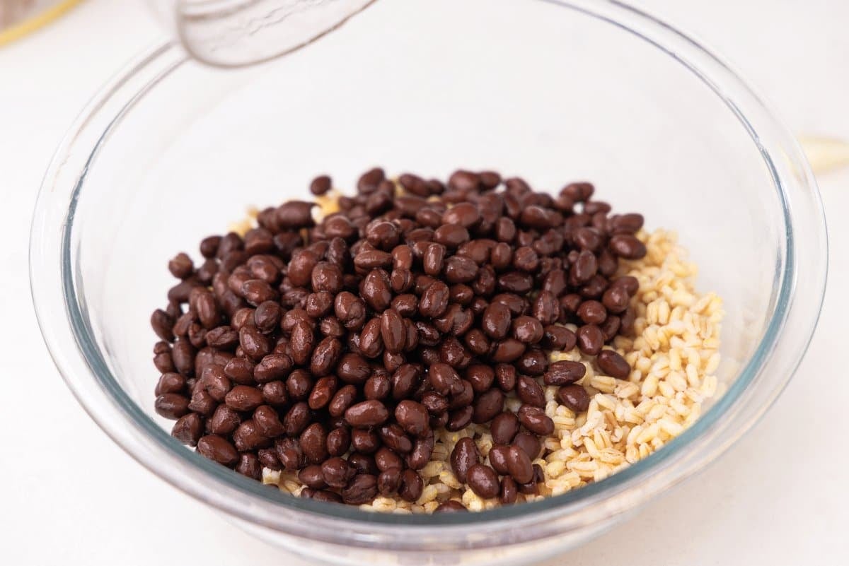 Black beans added to bowl with barley.