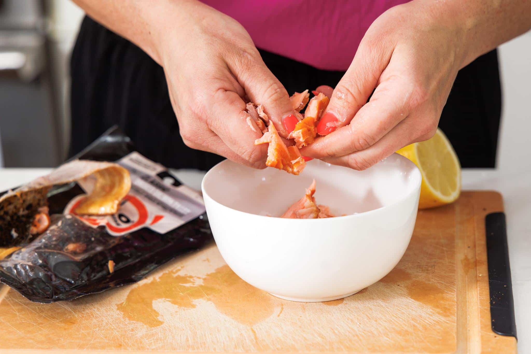 Breaking up smoked salmon into a small bowl.