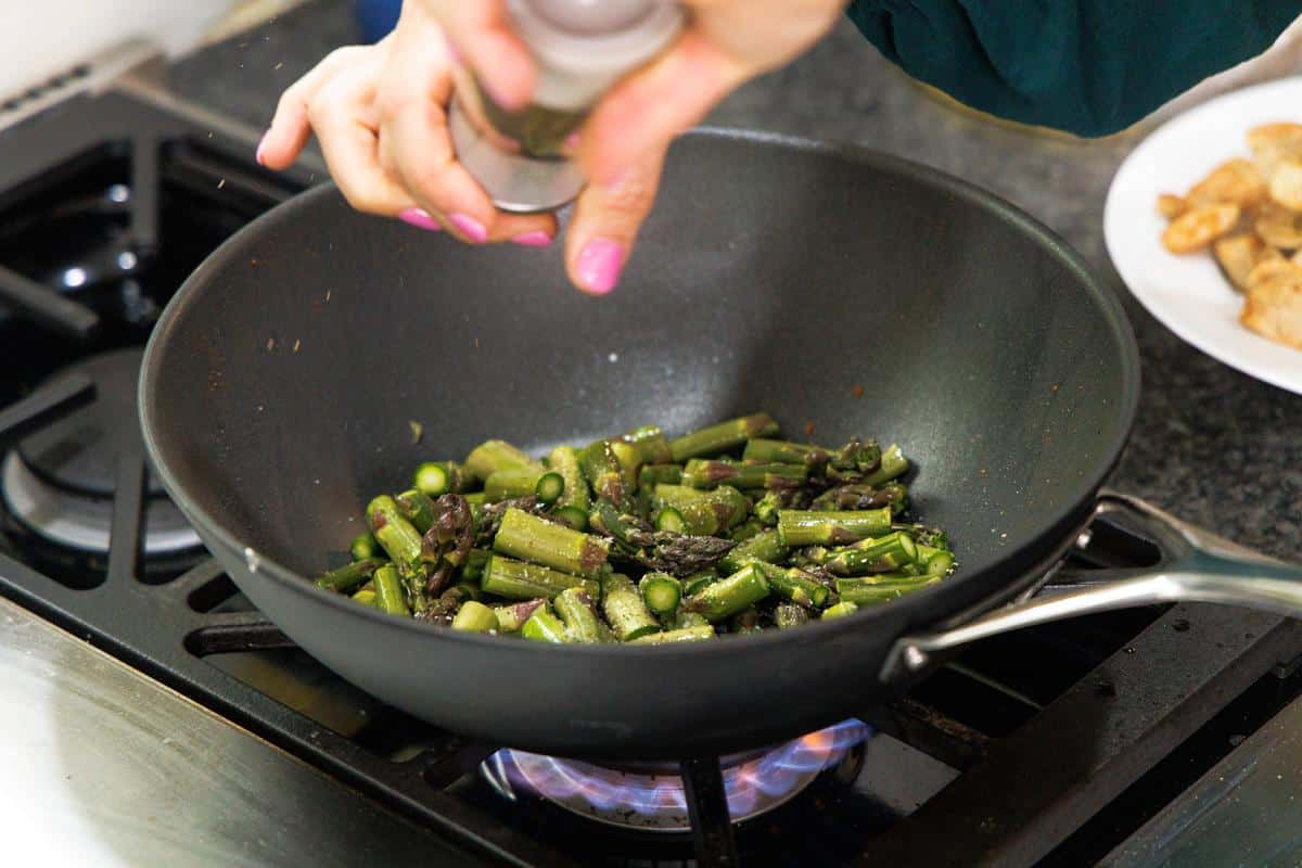 Cooking asparagus in a large wok.
