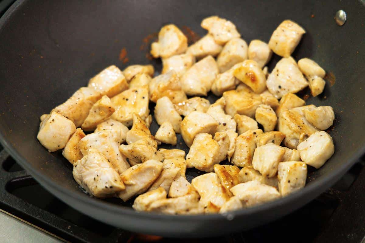Cooking chicken in a large wok.