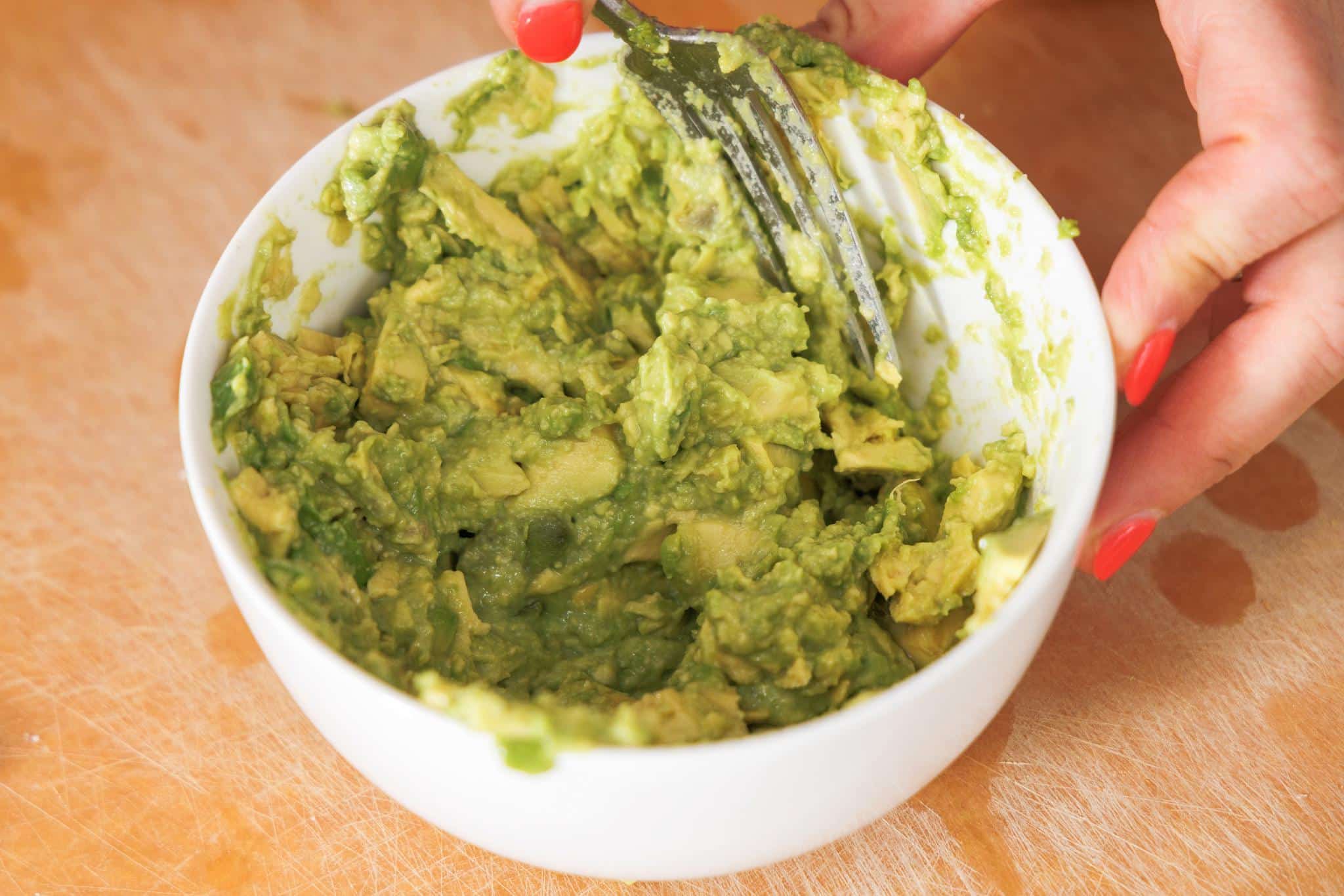 Mashing fresh avocado with lemon juice.