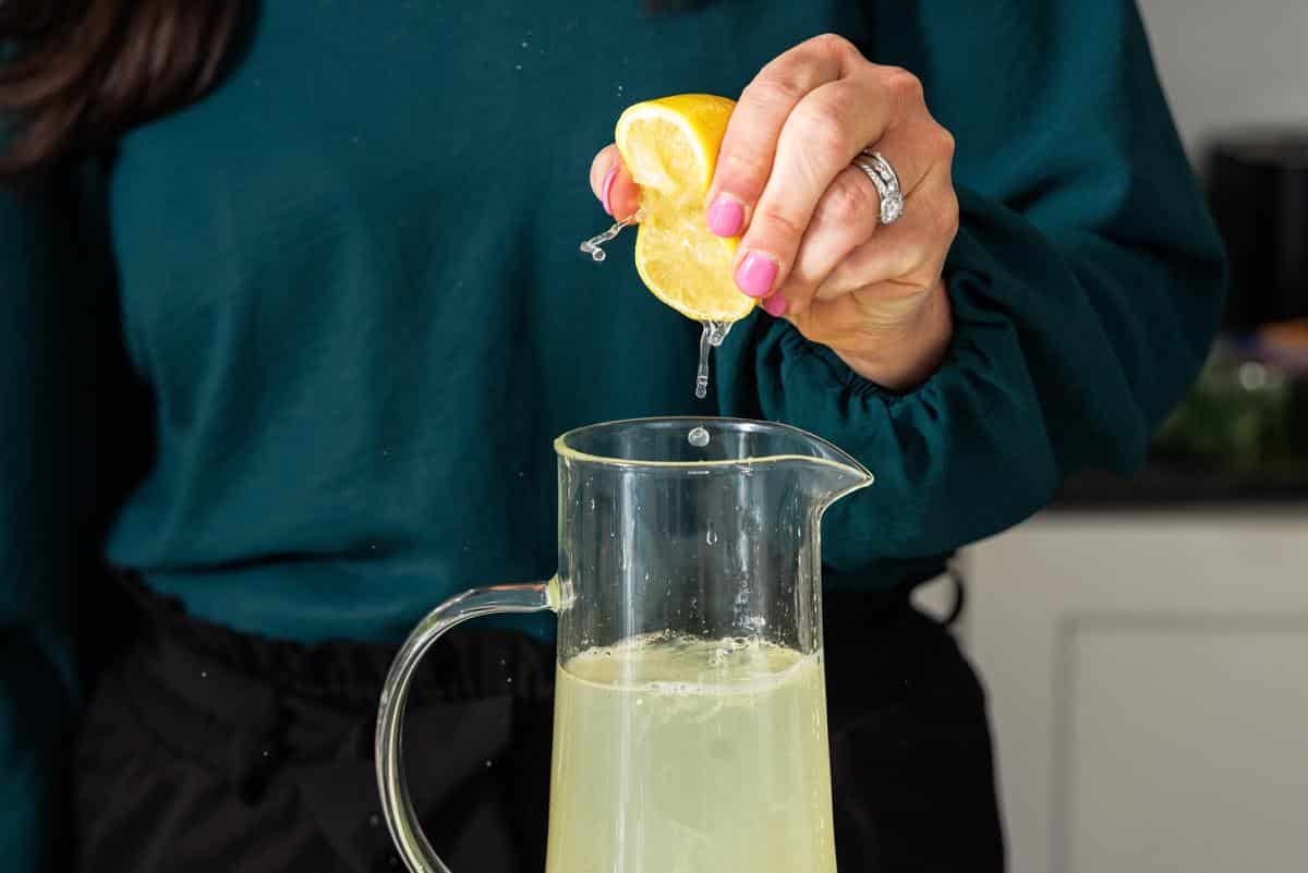 Freshly squeezing lemon juice into pitcher.
