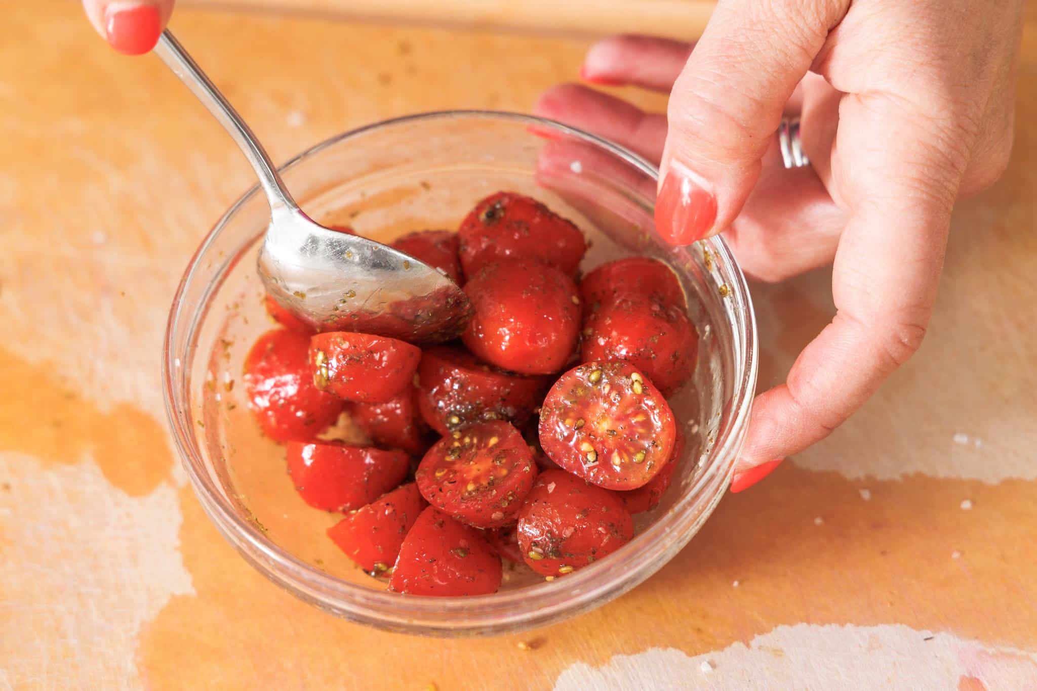 Tossing tomatoes in olive oil and za'atar.