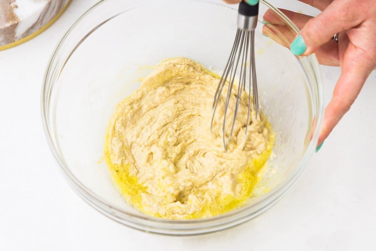 Whisking hummus with olive oil and lemon juice.