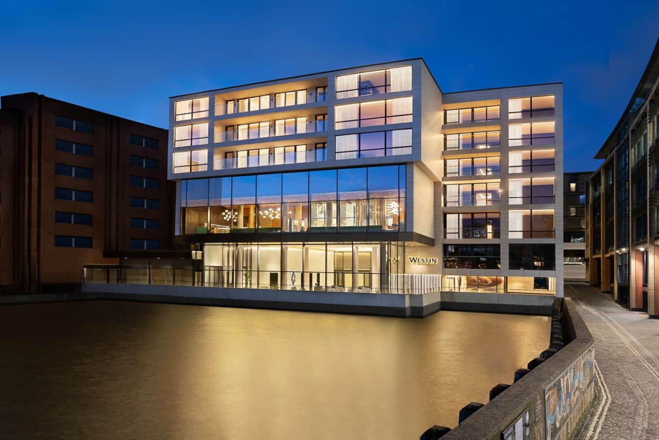 View of The Westin London City over the Thames river at night.